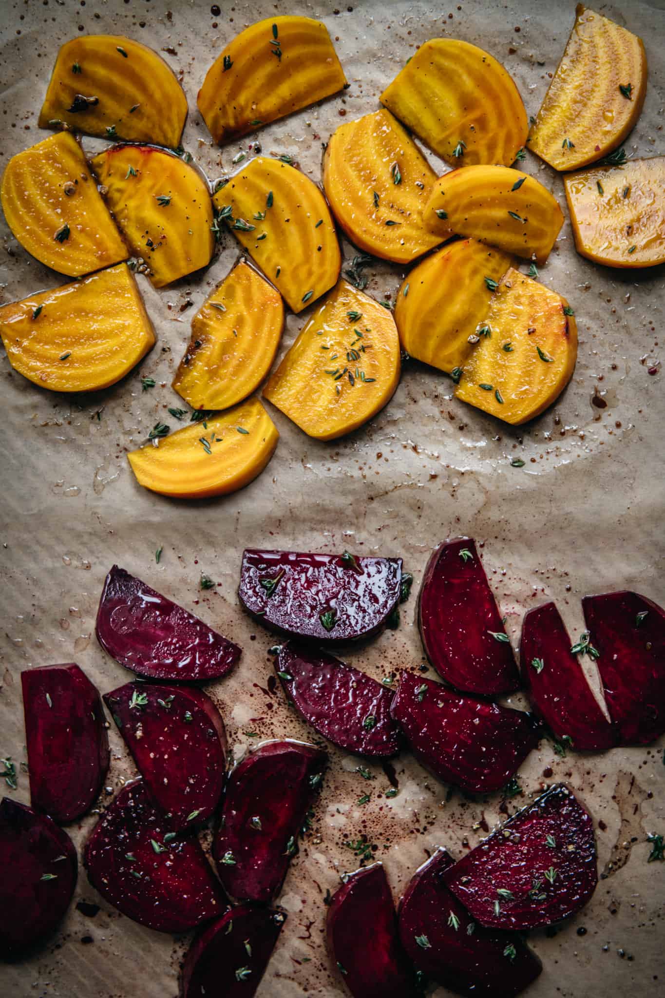 overhead view of golden and regular red beets on parchment paper