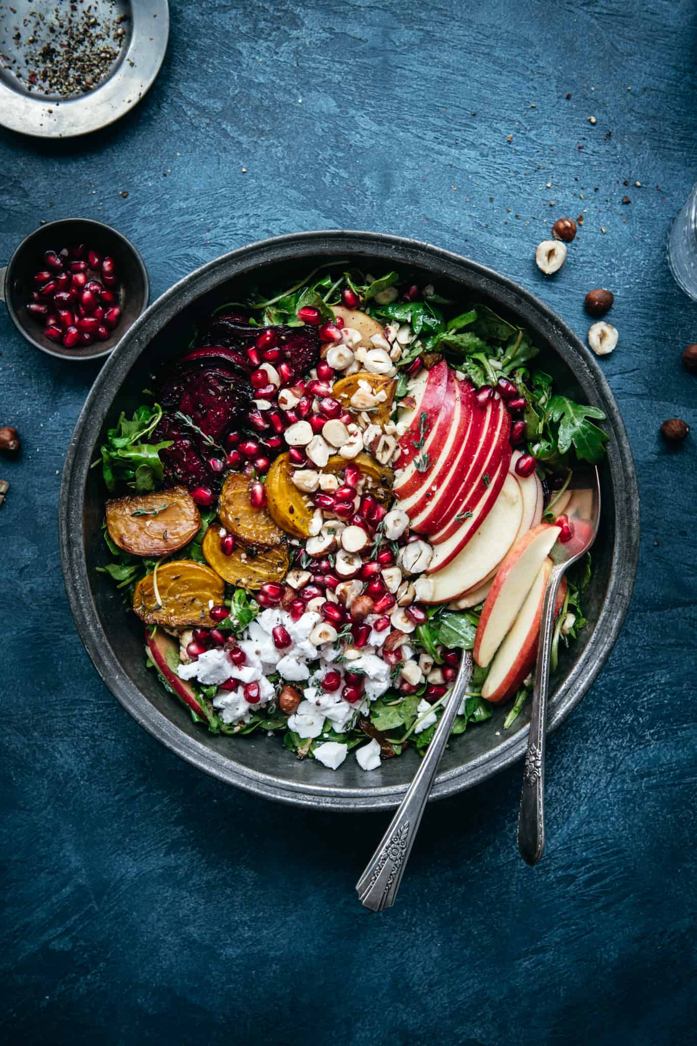 overhead view of beautiful roasted beet kale salad in a bowl on a blue background