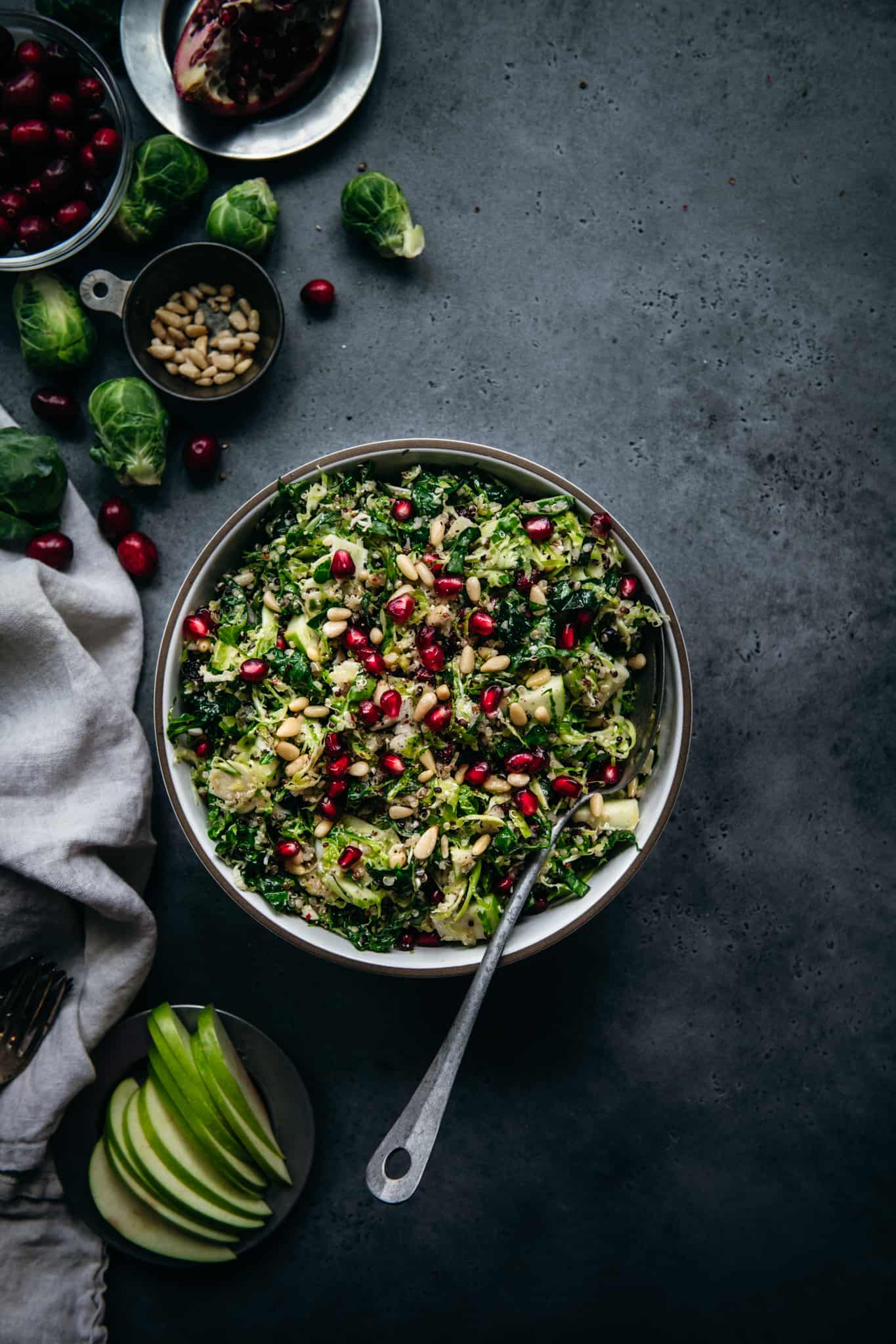 overhead of a bowl of shaved brussels sprout kale salad on a dark background