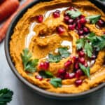 45 degree overhead of vegan smoky carrot dip in a bowl topped with pomegrate seeds