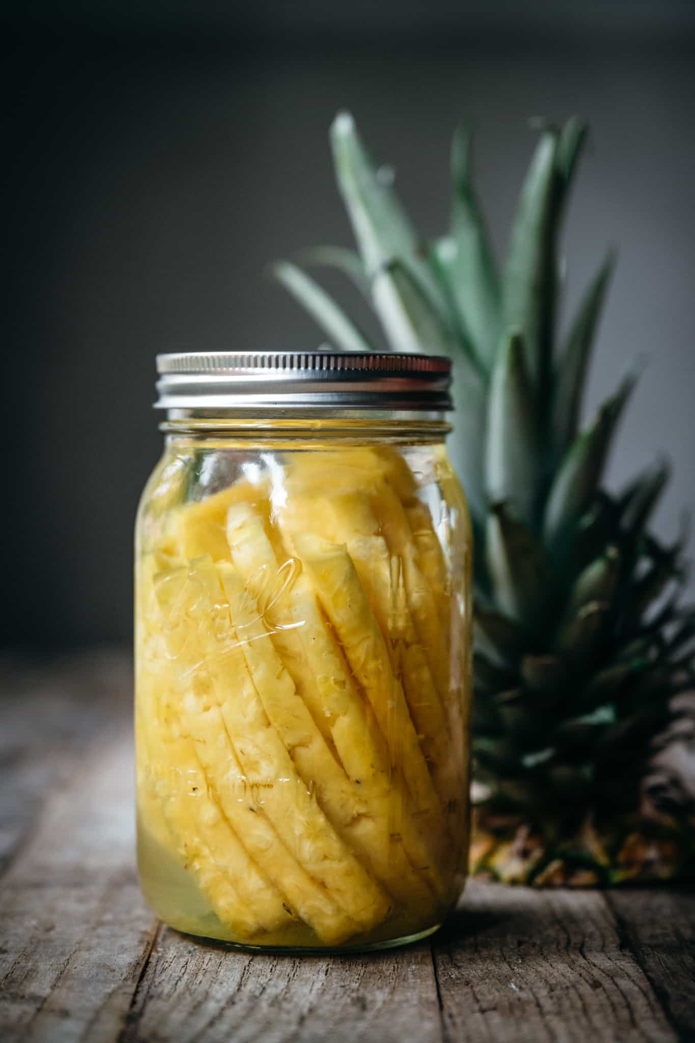 side view of pineapple infused rum in mason jar
