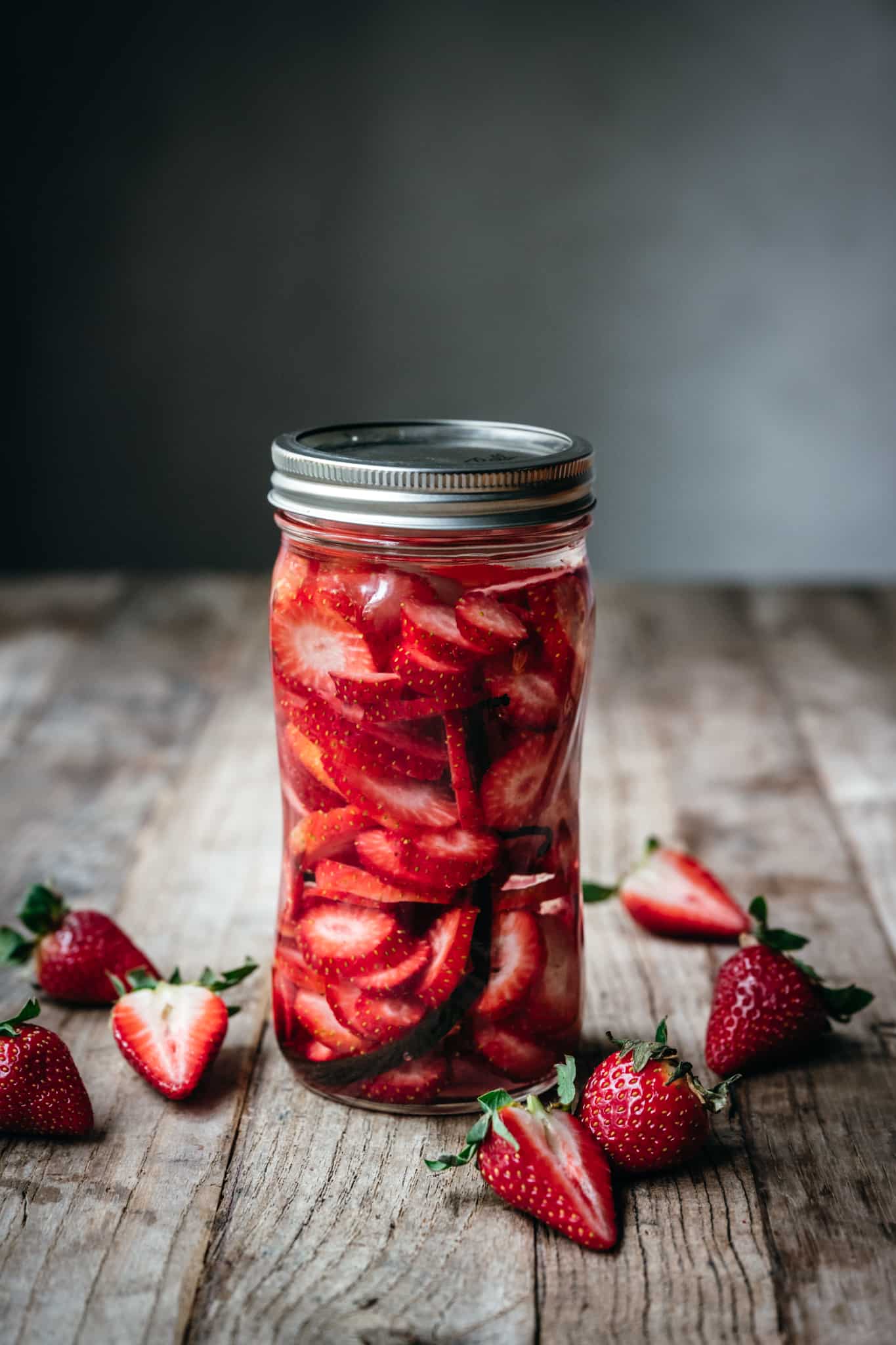 side view of strawberry vanilla infused vodka in a ball jar