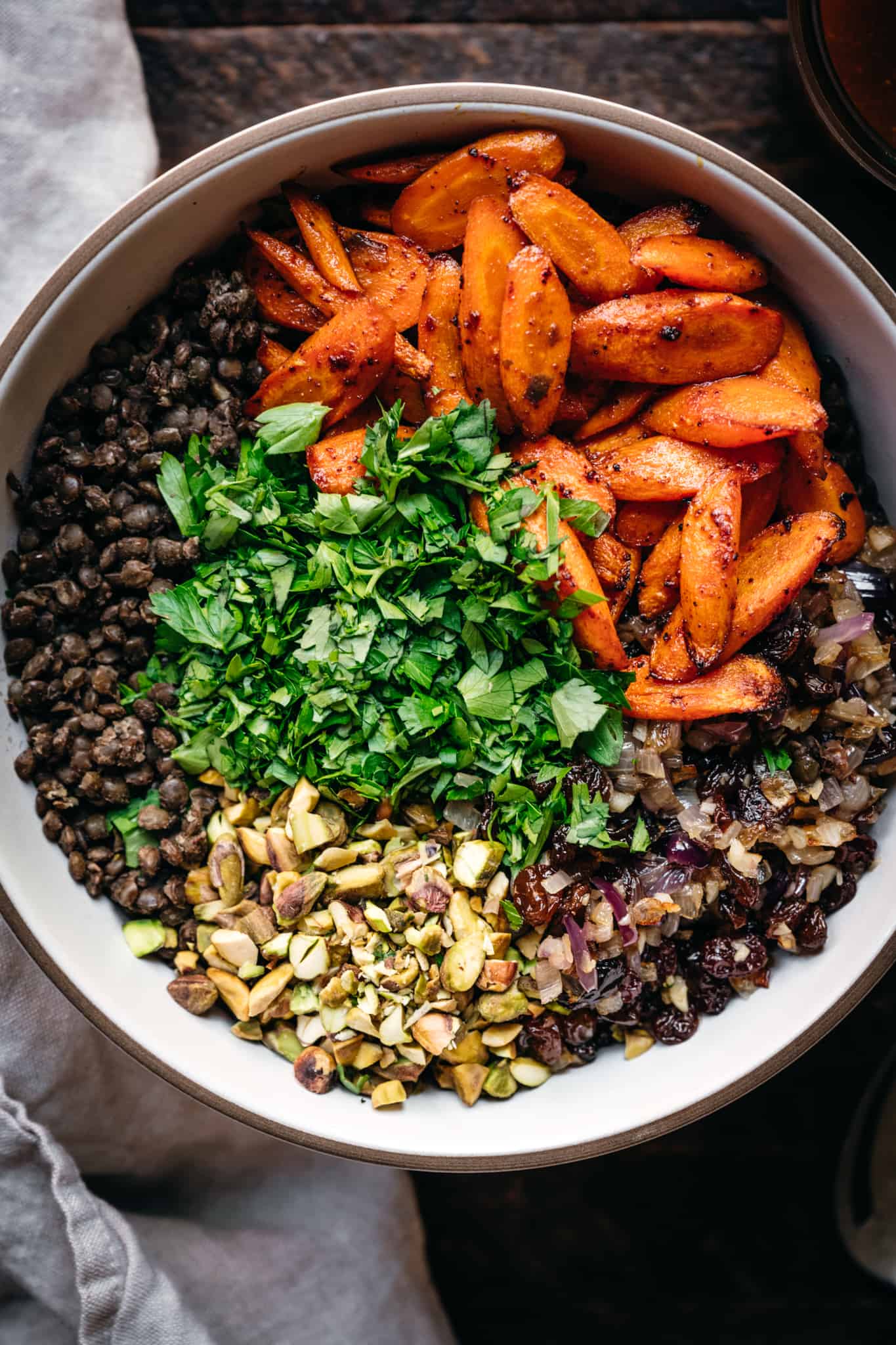 overhead view of ingredients in white bowl to make vegan french lentil salad with moroccan dressing