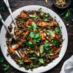 overhead view of moroccan lentil salad on a white plate with roasted carrots