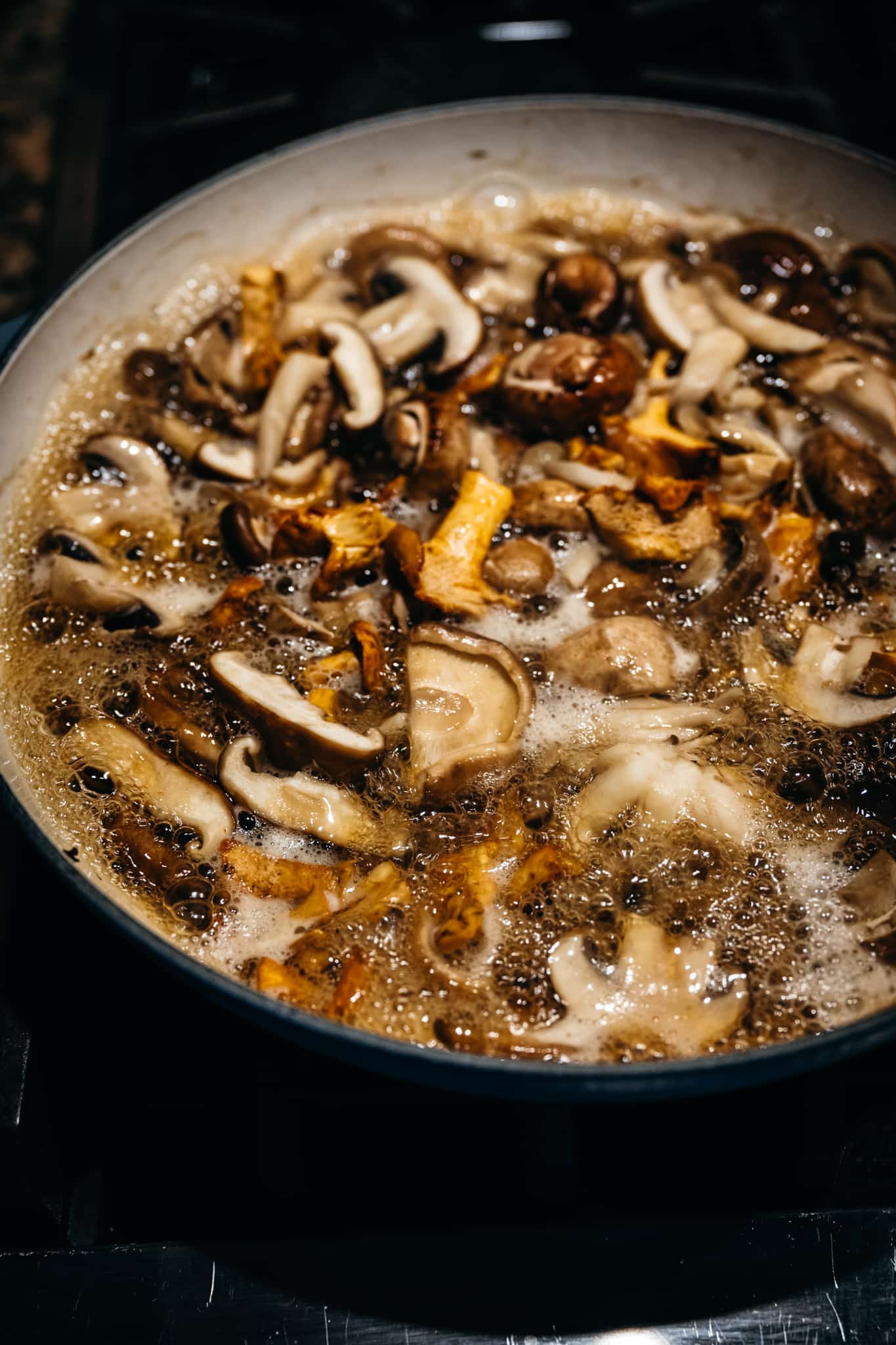 close up of wild mushrooms in a skillet cooked to release their water