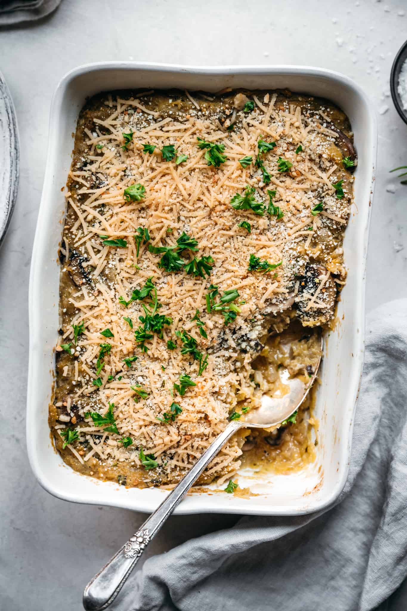 close up overhead of texture on a vegan spaghetti squash casserole with a spoon in the dish