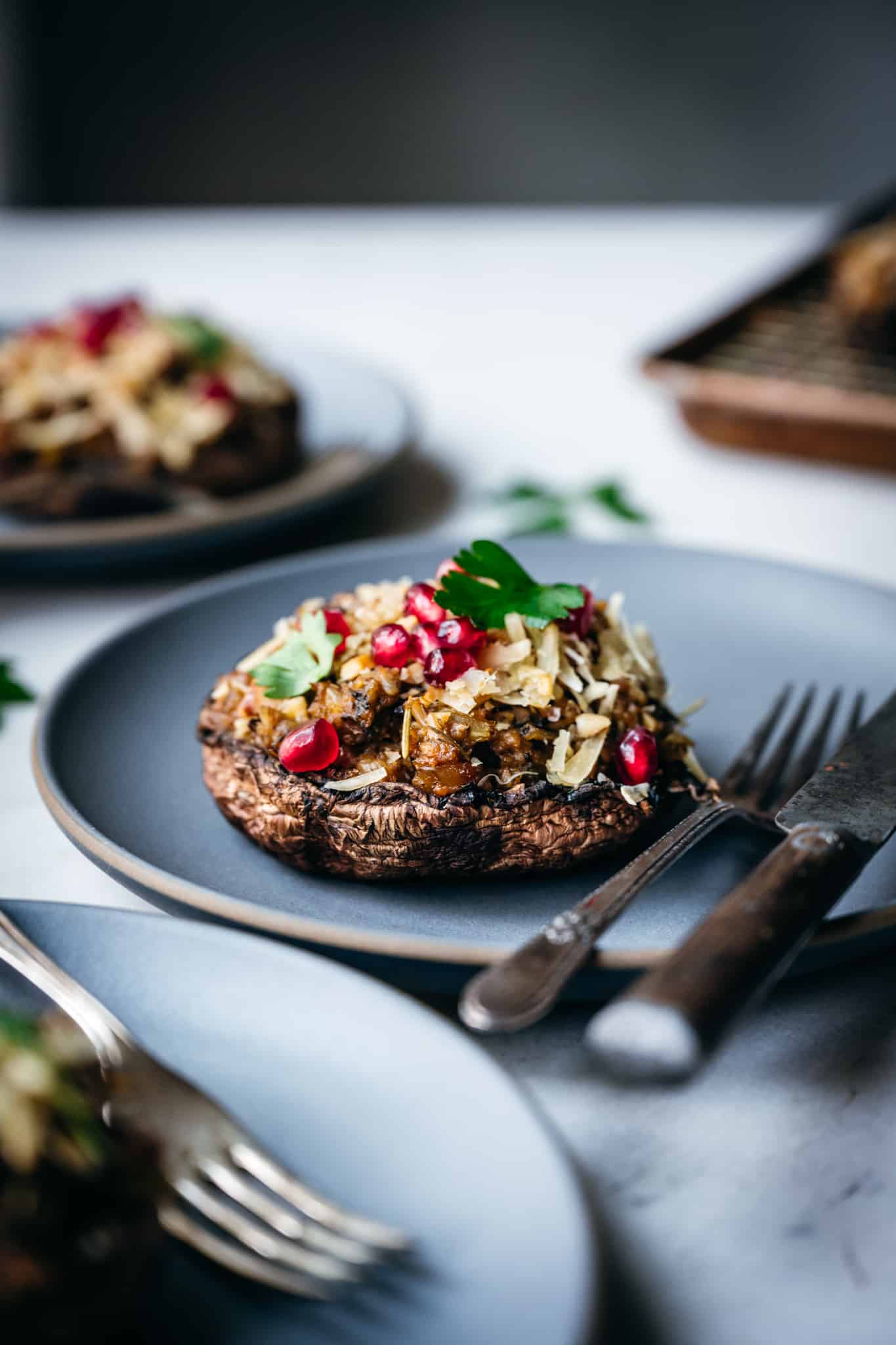 side view of vegan stuffed portobello mushroom with gluten free filling on a gray plate