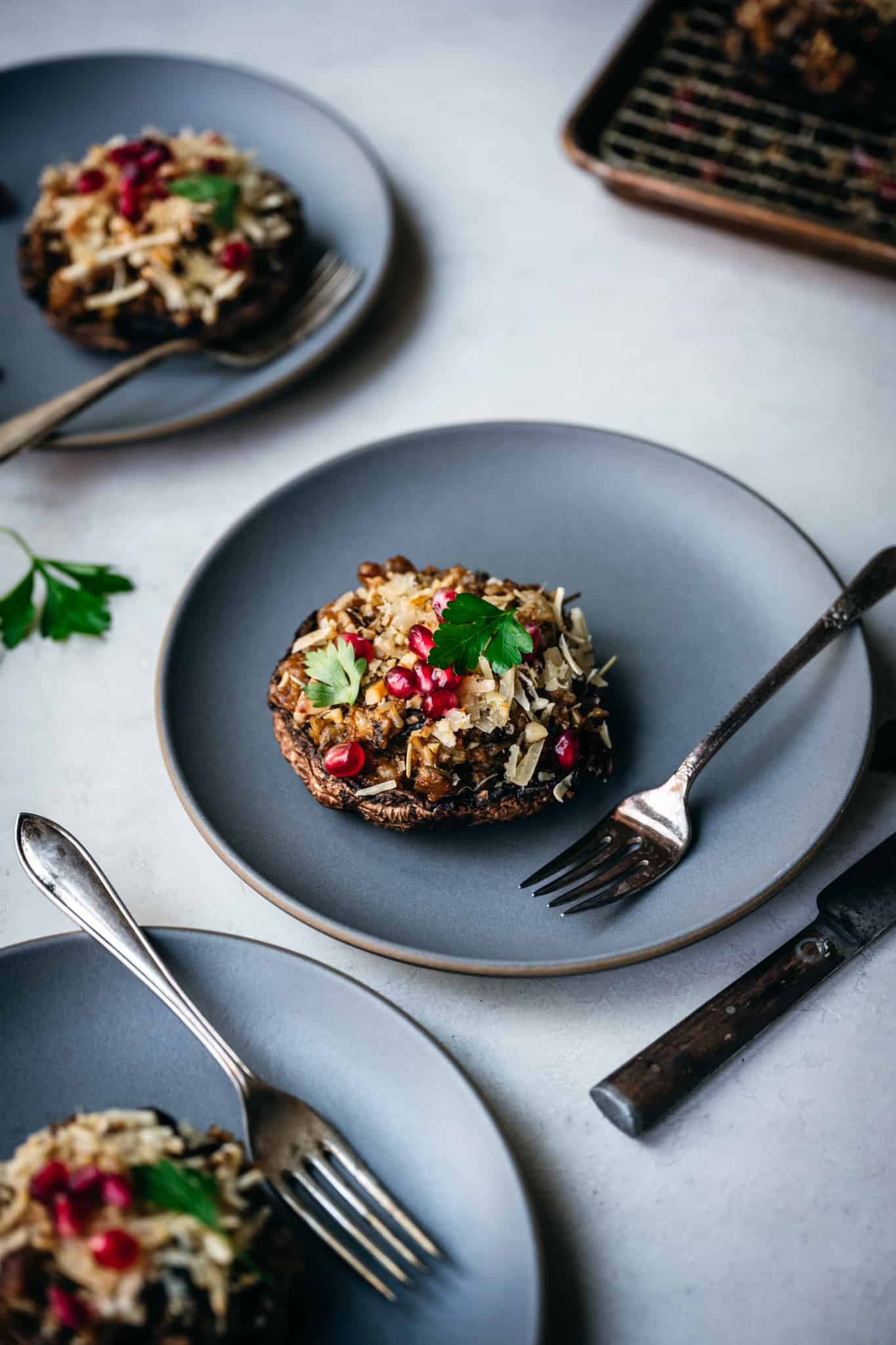 side view of stuffed portobello mushroom on blue plate with fork