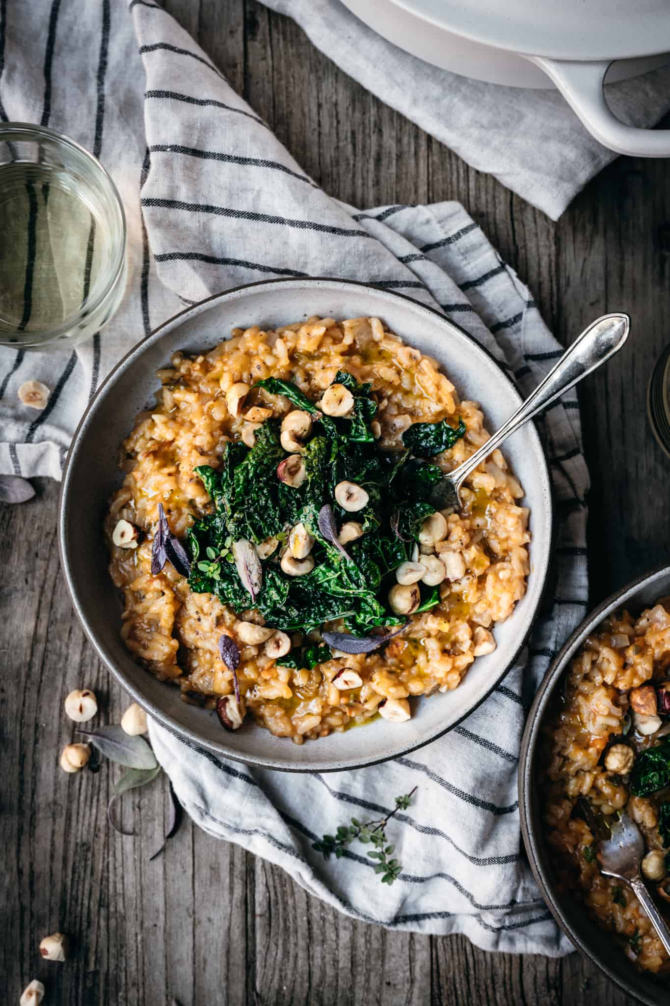 overhead view of sweet potato risotto with kale and hazelnuts in a ceramic bowl