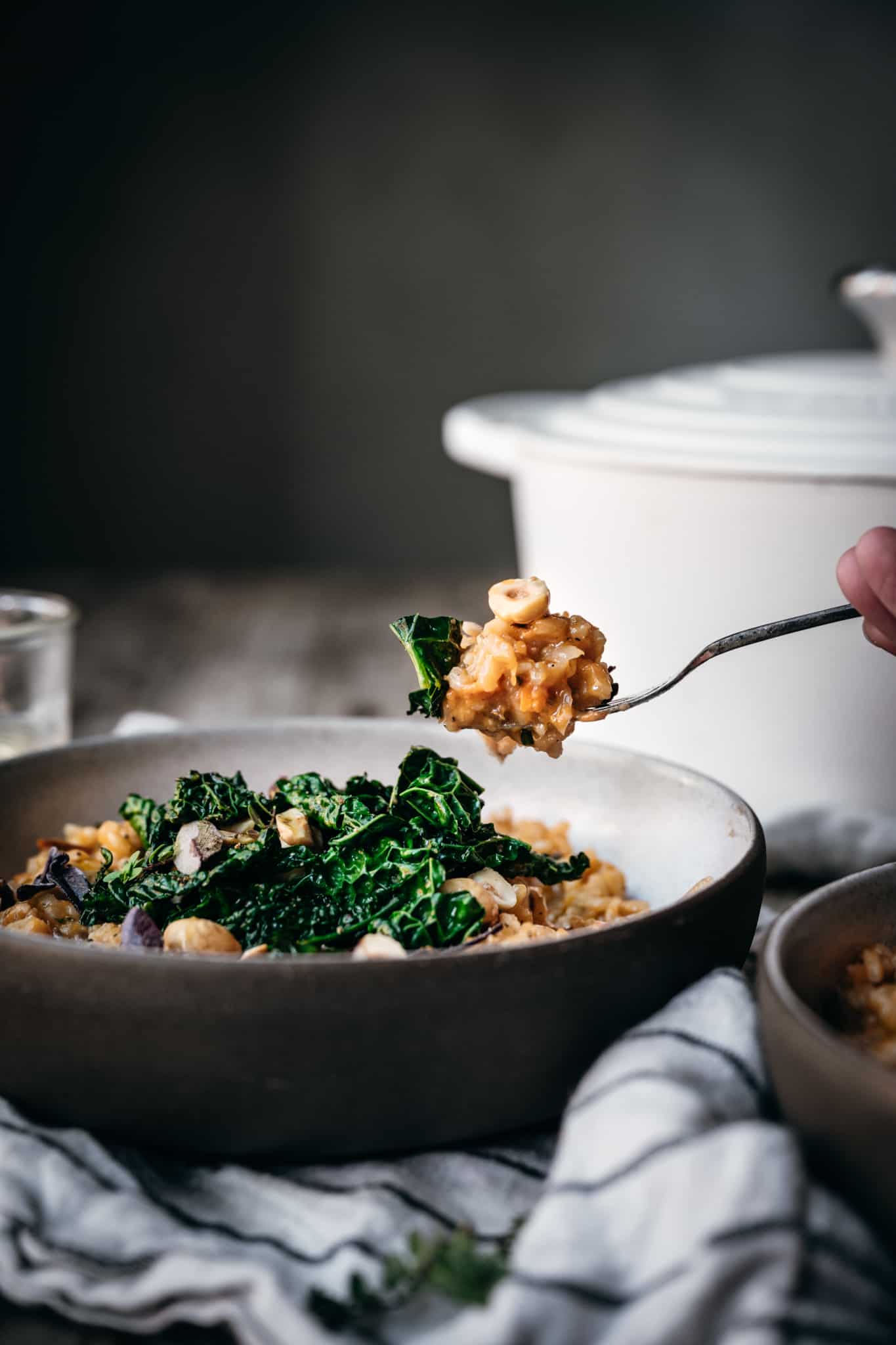 side view of forkful of vegan sweet potato risotto with kale and hazelnuts