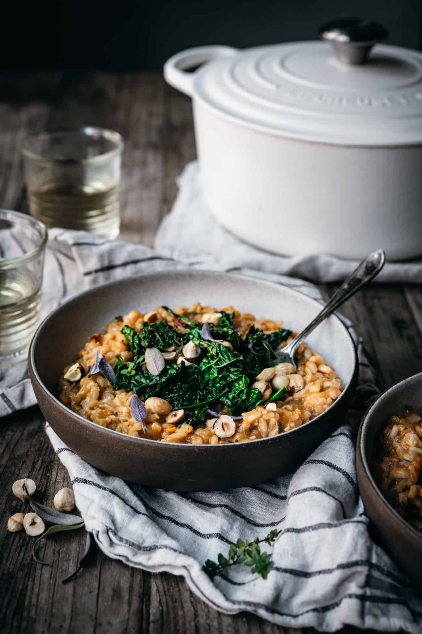 Side view of vegan sweet potato risotto topped with kale and hazelnuts
