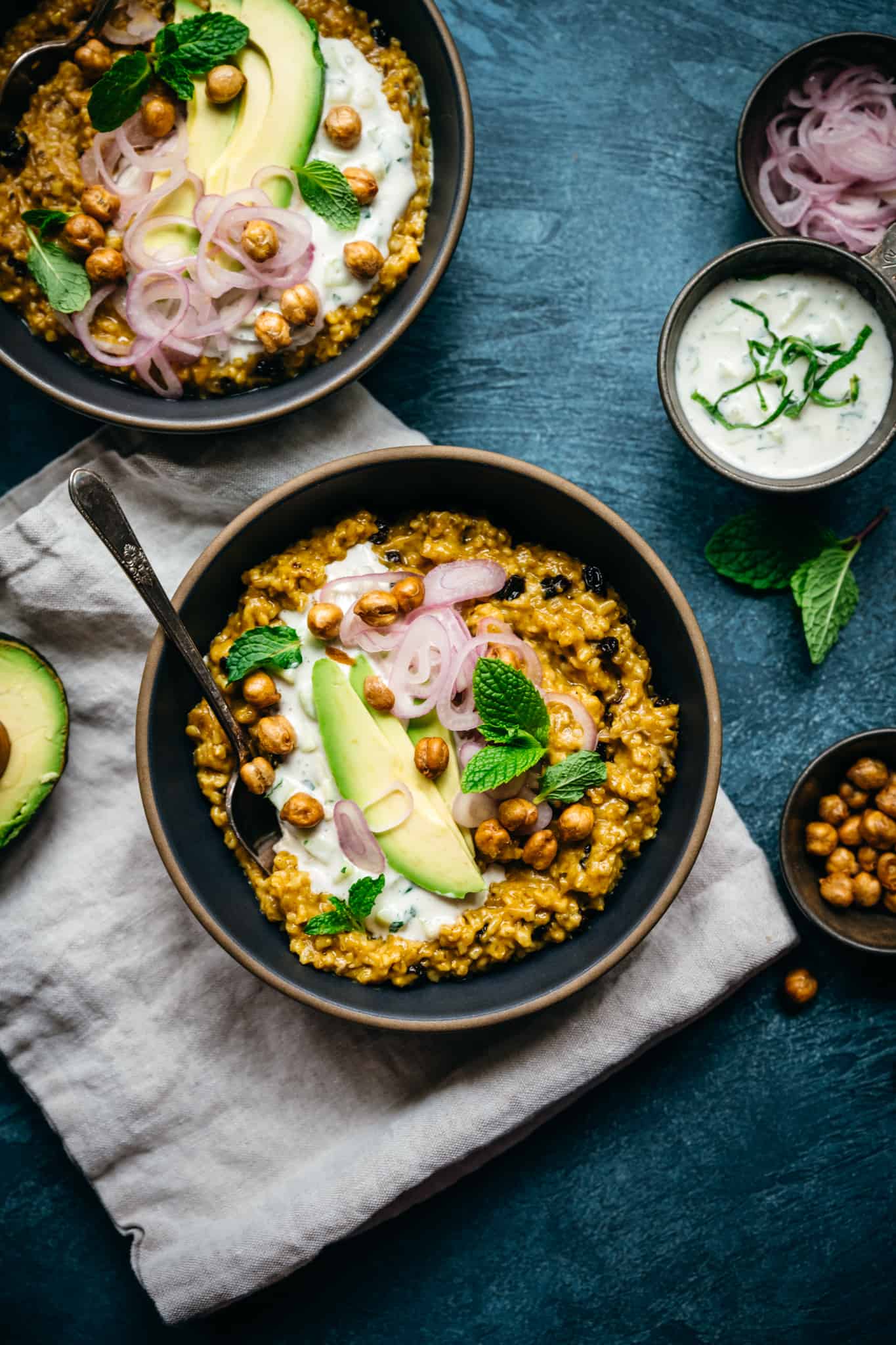 overhead view of savory indian-spiced steel cut oats with avocado, pickled shallots and chickpeas