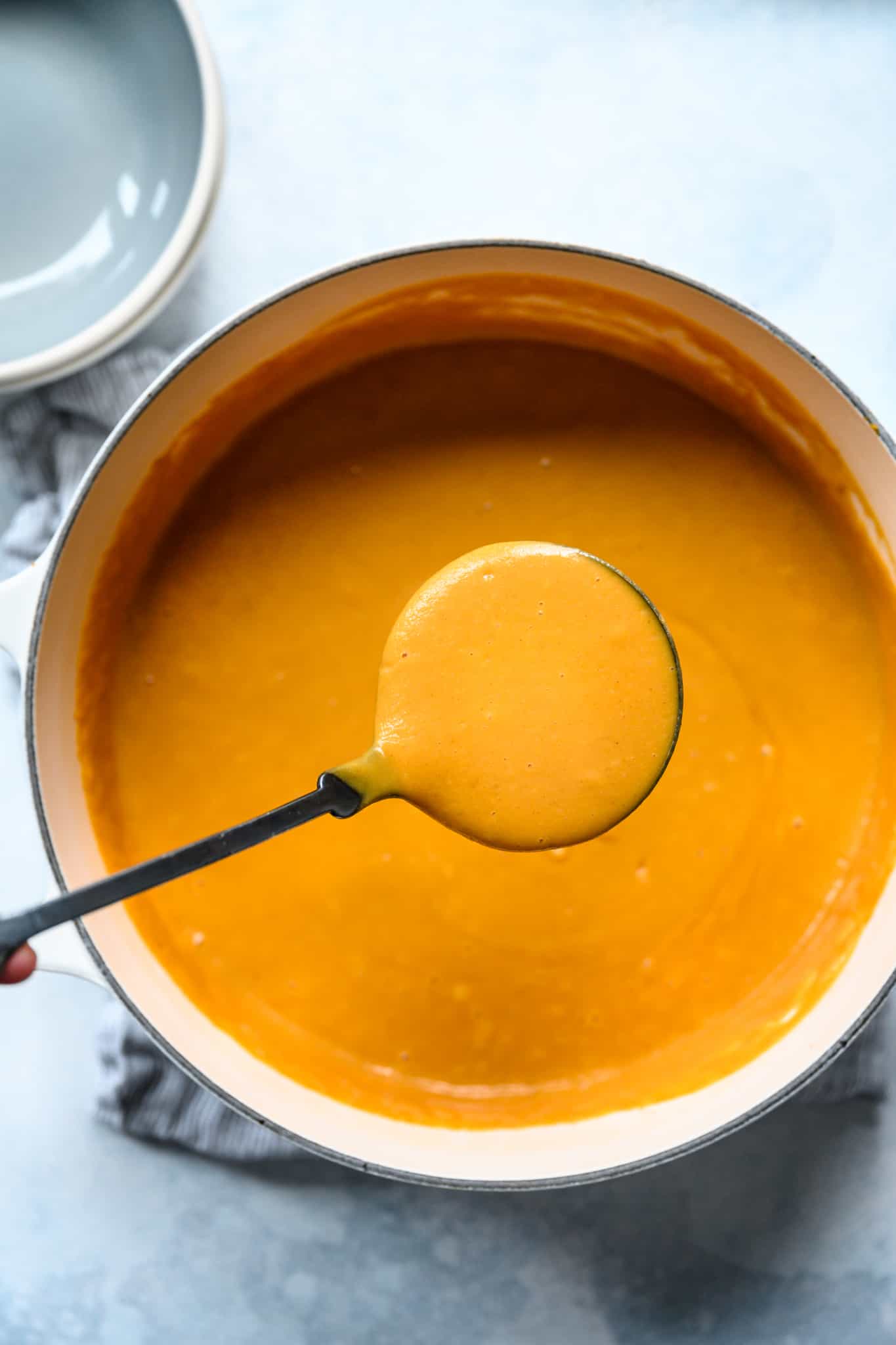 overhead of a pot of roasted beet soup with a ladel of soup