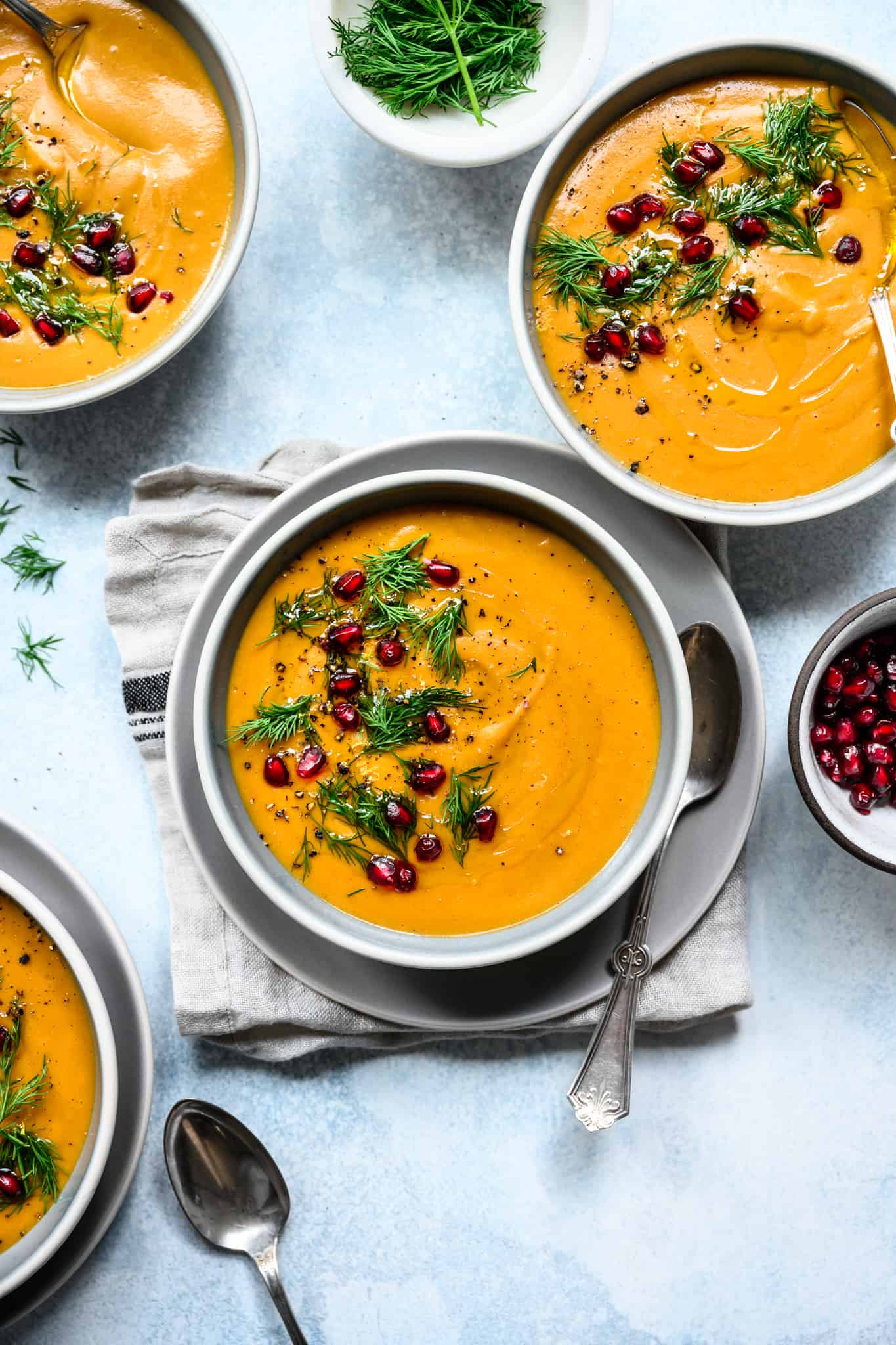 overhead of creamy golden beet soup in a white bowl on a white plate