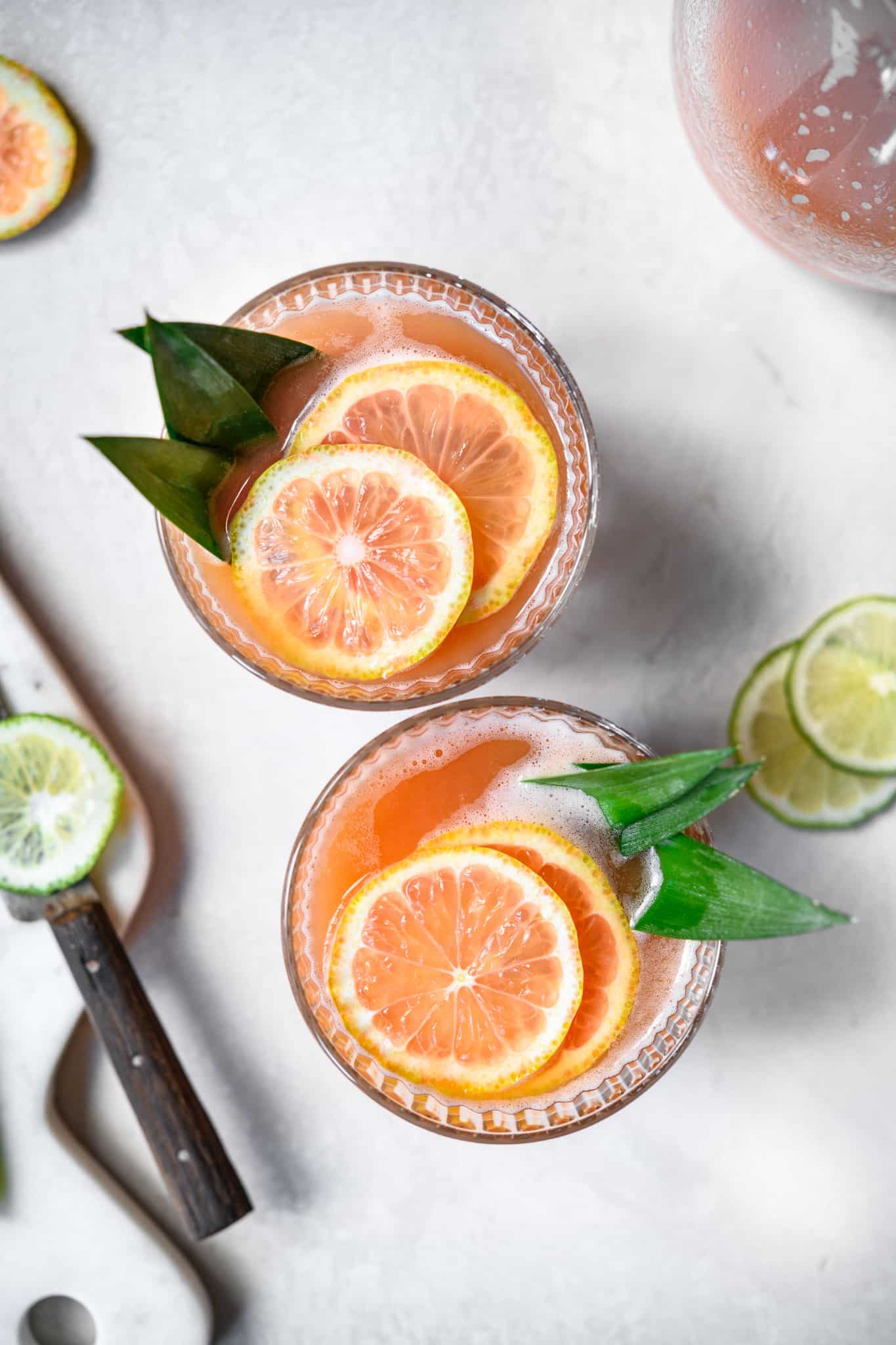 overhead view of two guava cocktails with pink lemon garnish