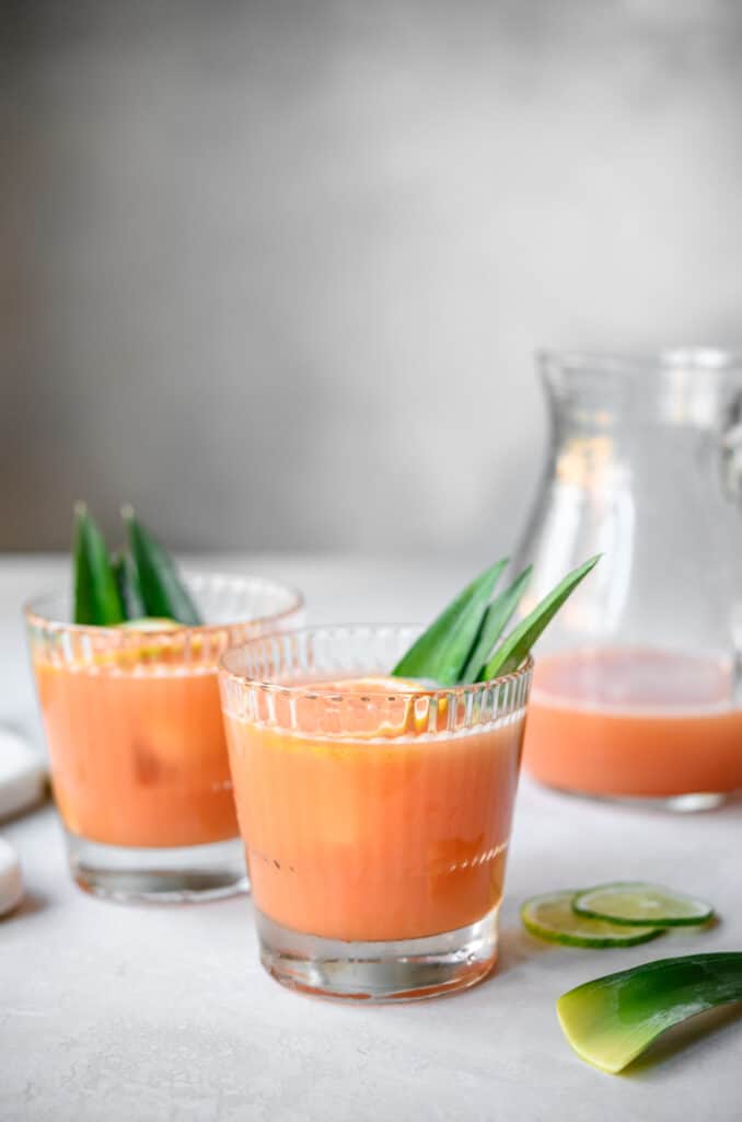 side view of two glasses of guava rum cocktail with pineapple infused rum