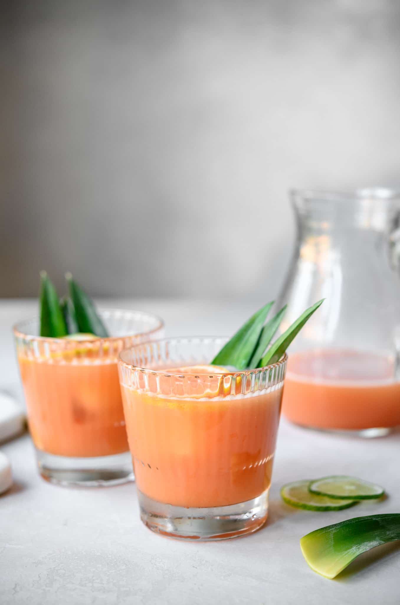 side view of two glasses of guava rum cocktail with pineapple infused rum