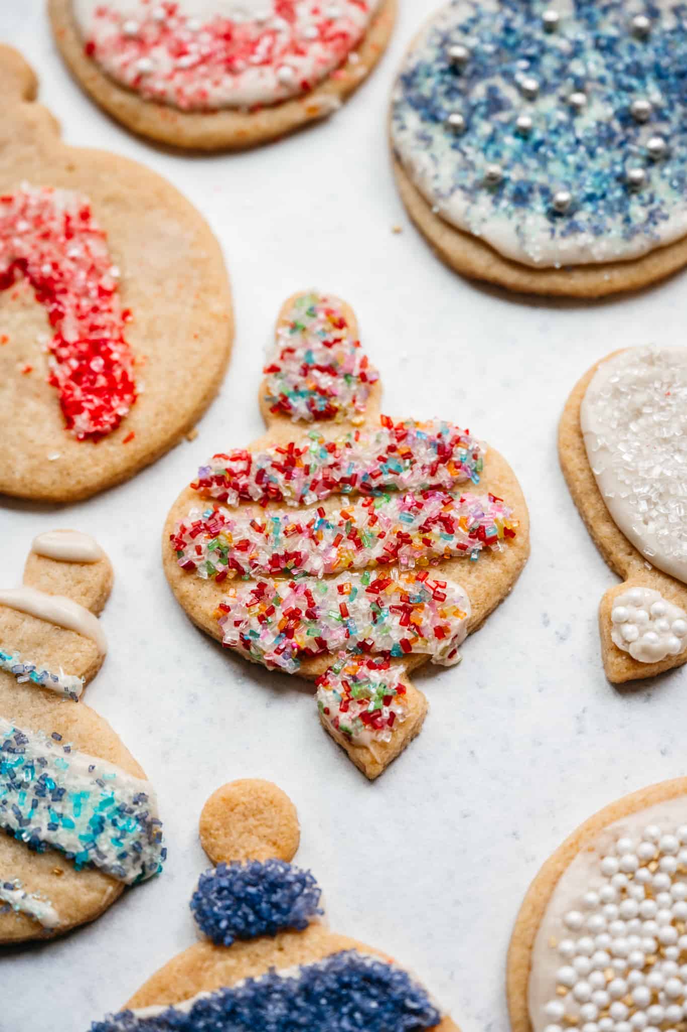 close up side view of vegan christmas sugar cookie in ornament shape with sprinkles