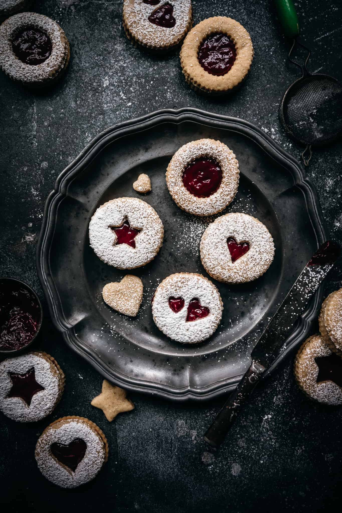 overhead view of raspberry linzer cookies on an antique plate