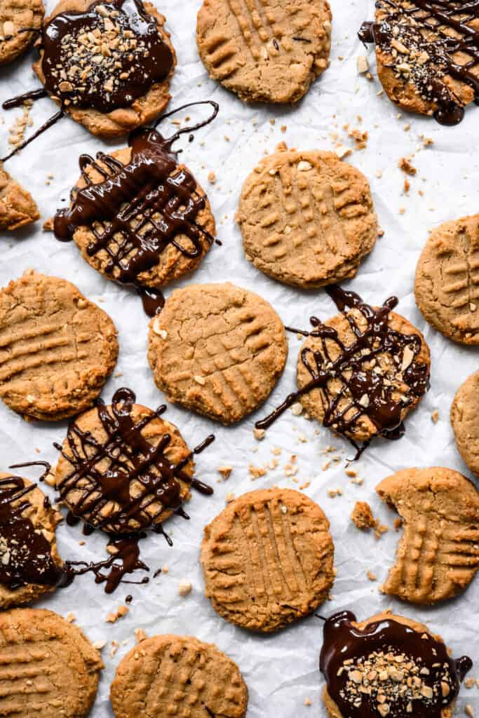 vegan peanut butter cookies drizzled with chocolate on parchment paper