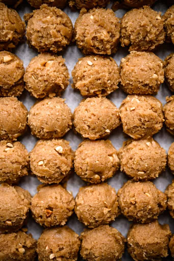 peanut butter cookie dough lined up on sheet pan before baking