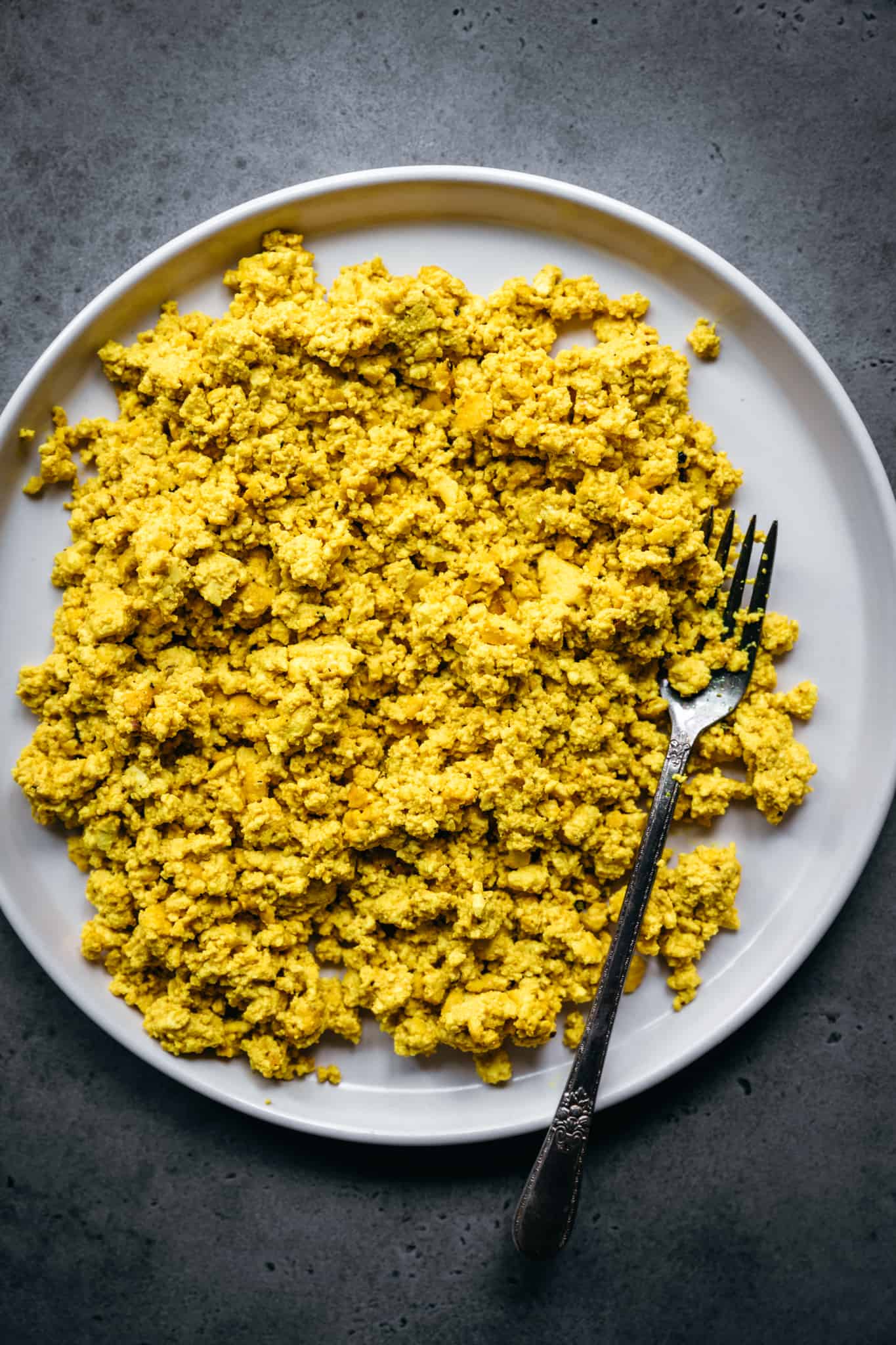 close up overhead view of vegan scrambled tofu on a white plate