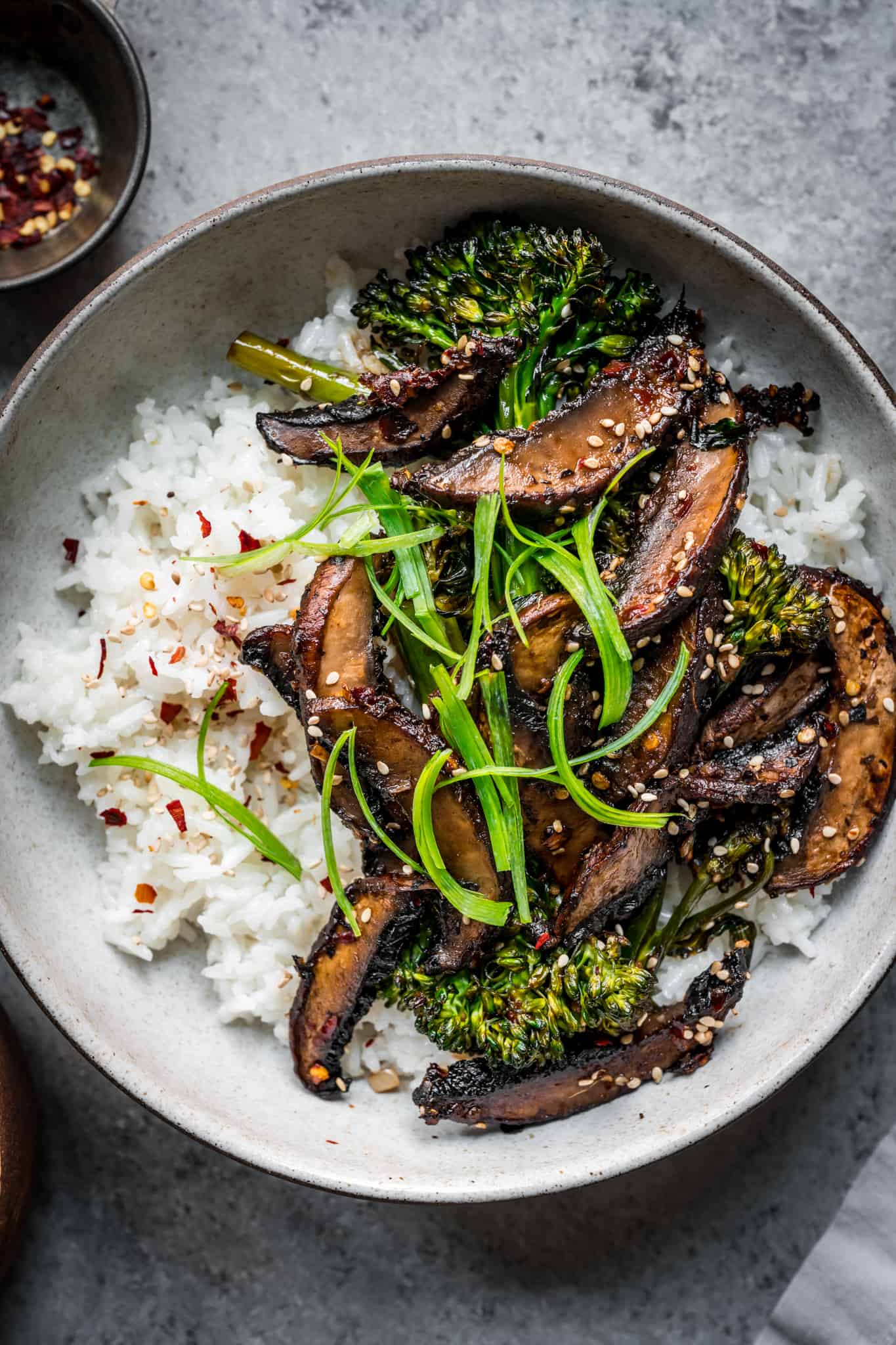 overhead of vegan teriyaki mushroom bowls with white rice and broccolini