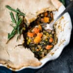 45 degree overhead of vegetarian pot pie with a piece taken out in a pie dish