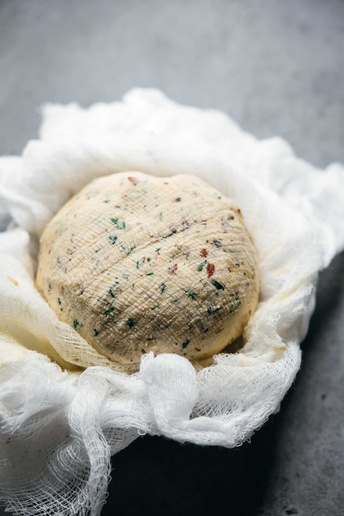overhead of a vegan cheeseball inside cheese cloth