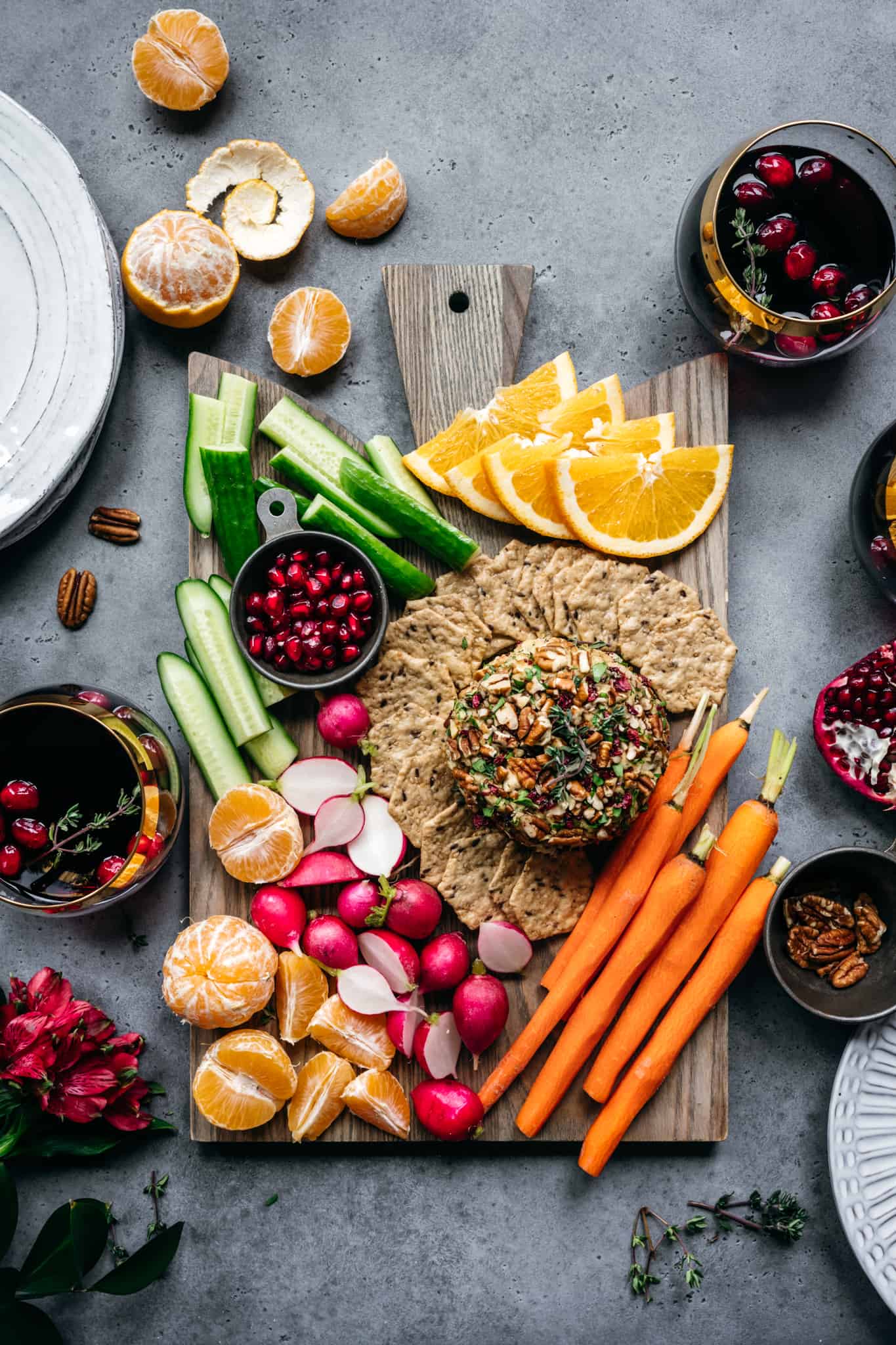 overhead of an appetizer board with a vegan cheese ball, crudite and fresh fruit