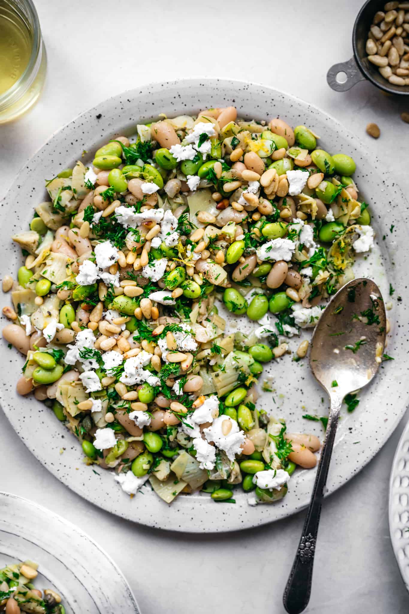 Close up view of vegan white bean salad on a white plate.