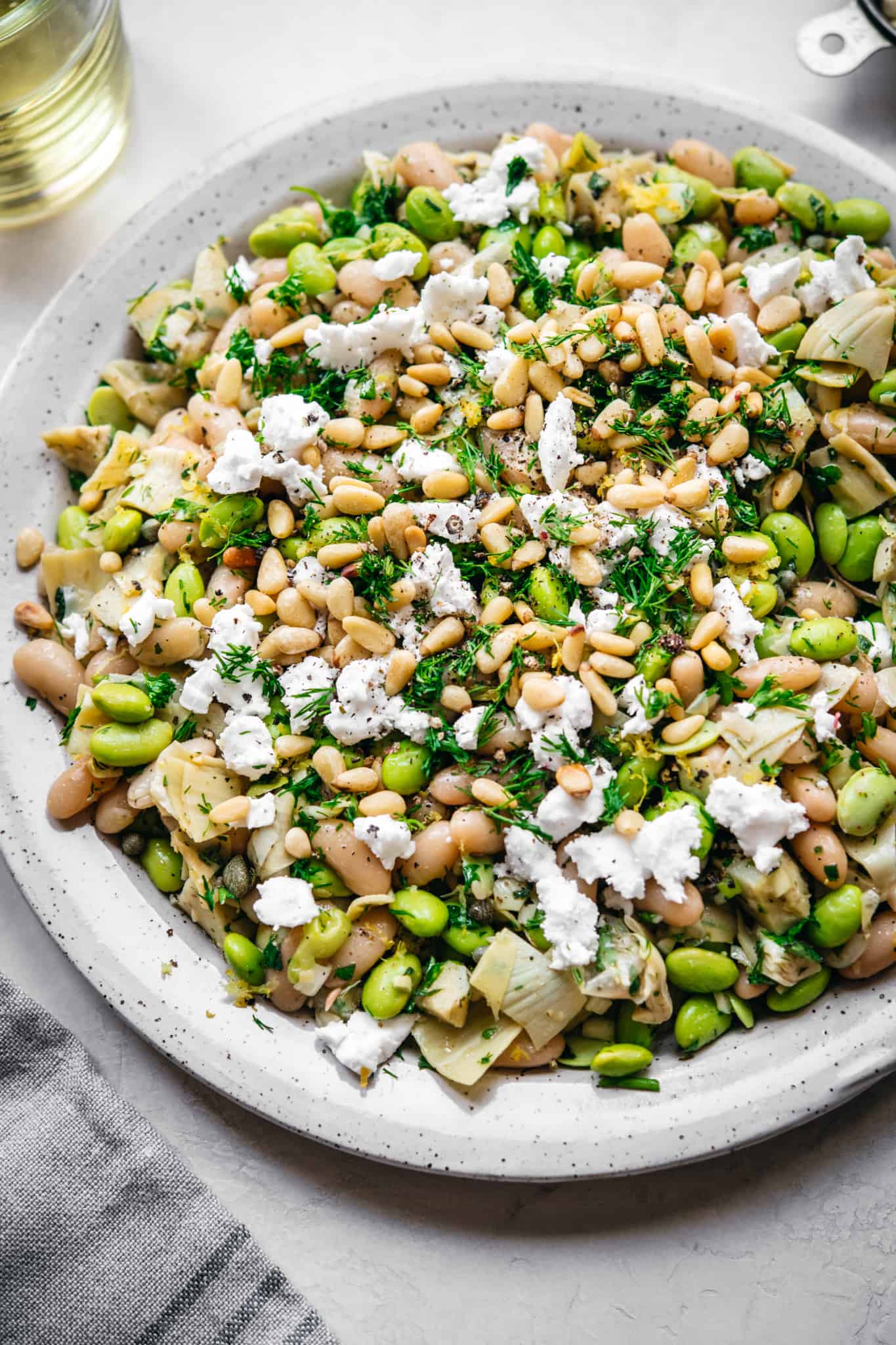 Close up side angle of vegan white bean salad on white plate.