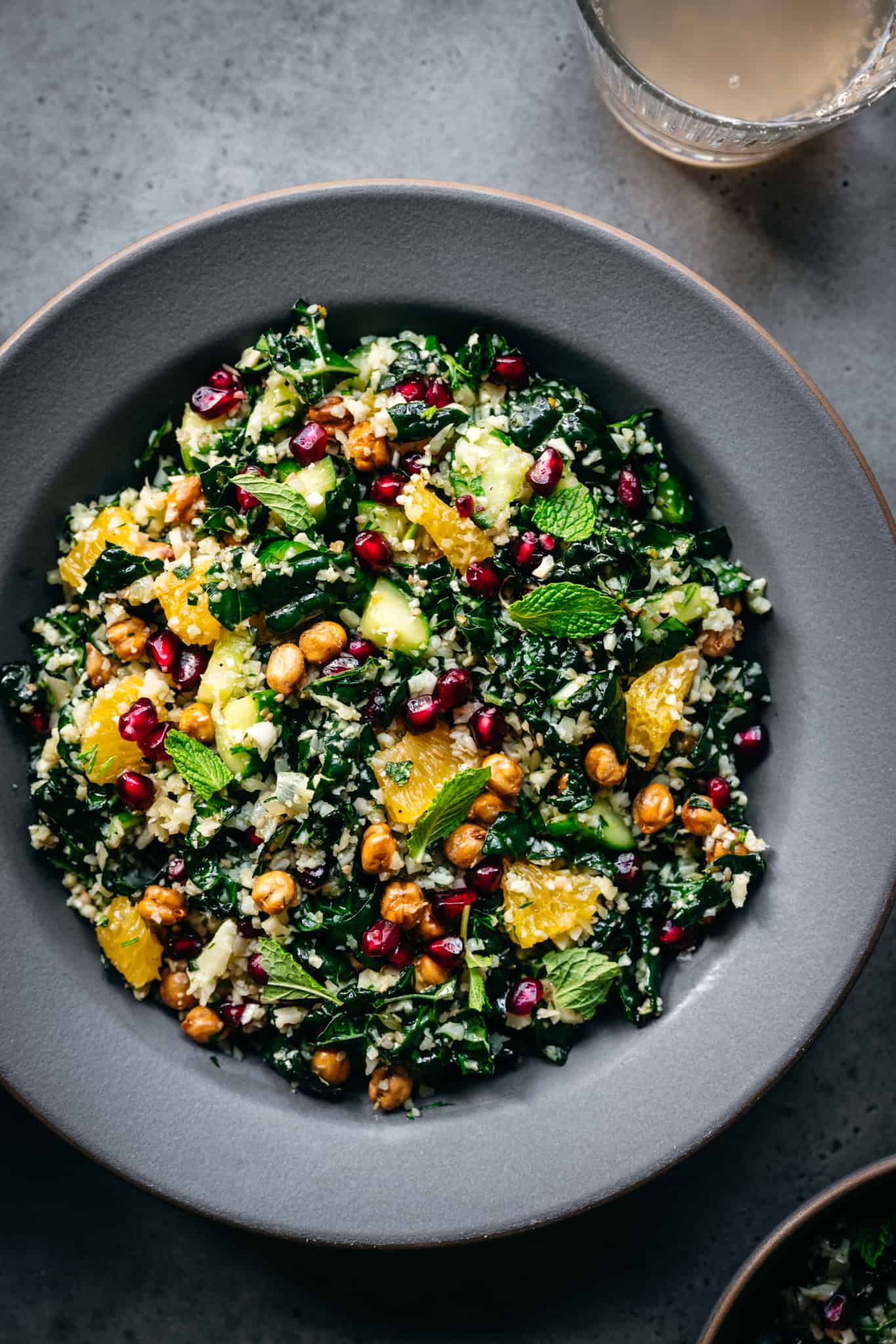 overhead view of mediterranean cauliflower rice salad with kale in a beautiful grey bowl