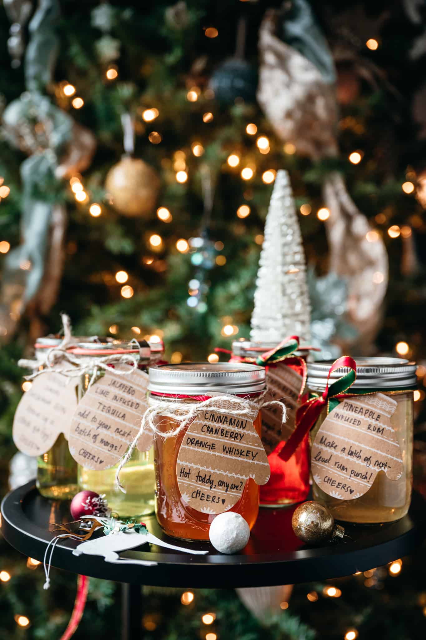 side view of homemade fruit infused liquors in front of a christmas tree