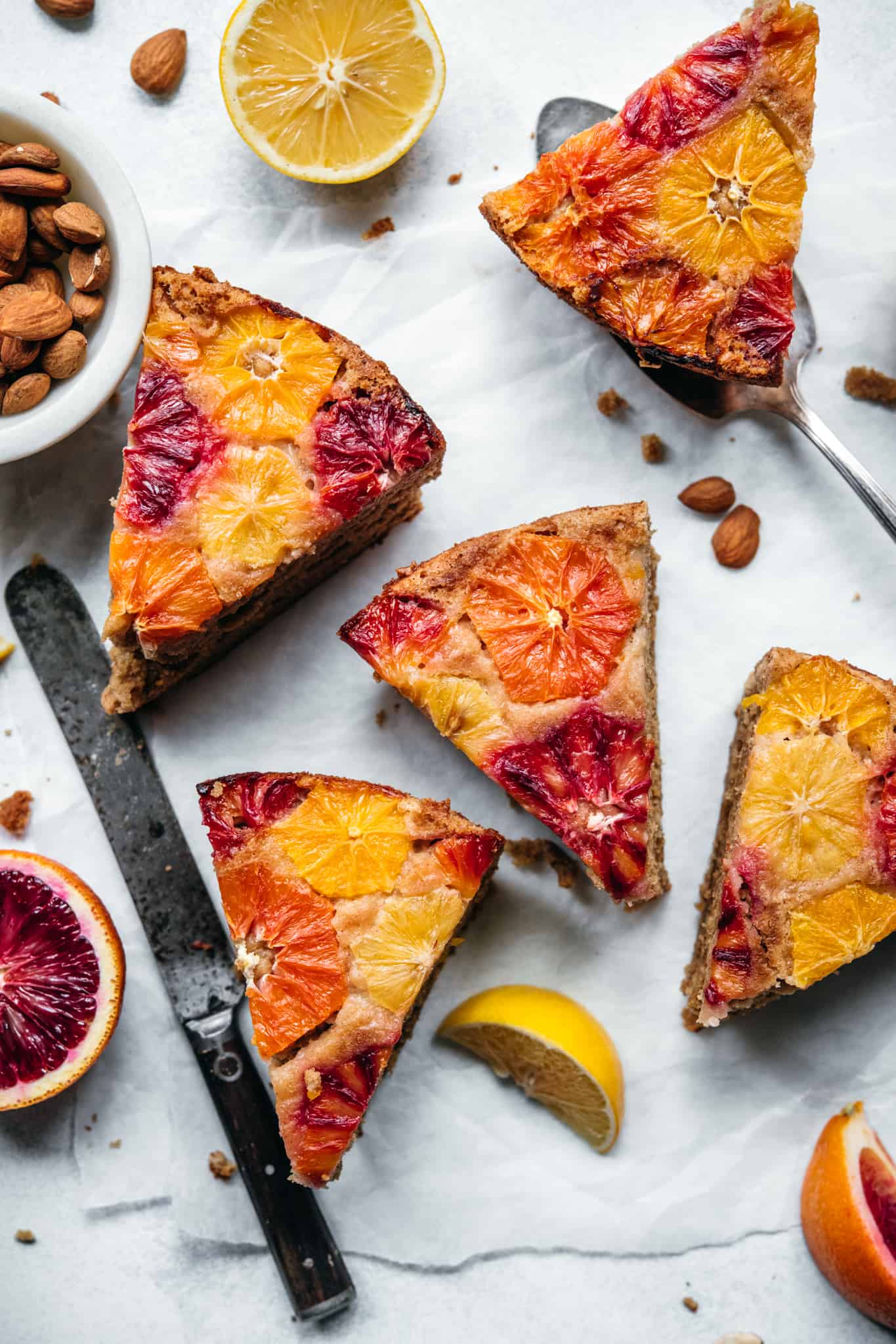 overhead view of slices of gluten free and vegan olive oil cake with citrus on top 
