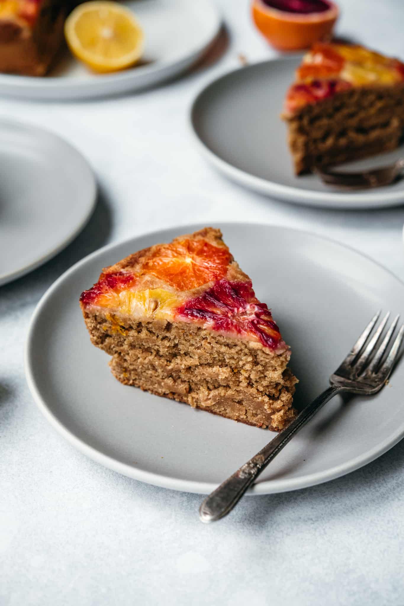 side view of slice of gluten free and vegan orange olive oil cake on a plate with fork