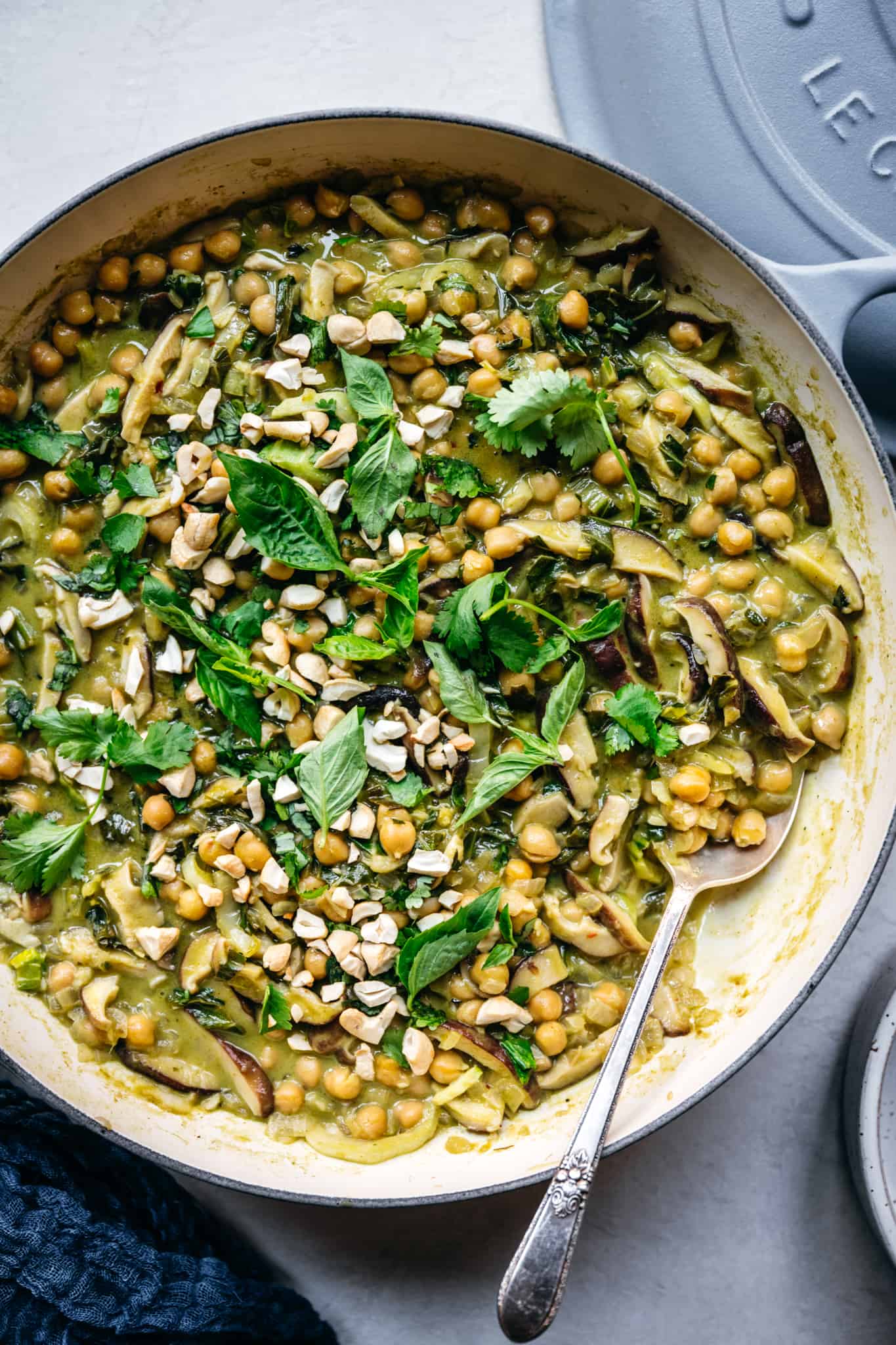 close up overhead view of vegan thai green curry with chickpeas in braiser