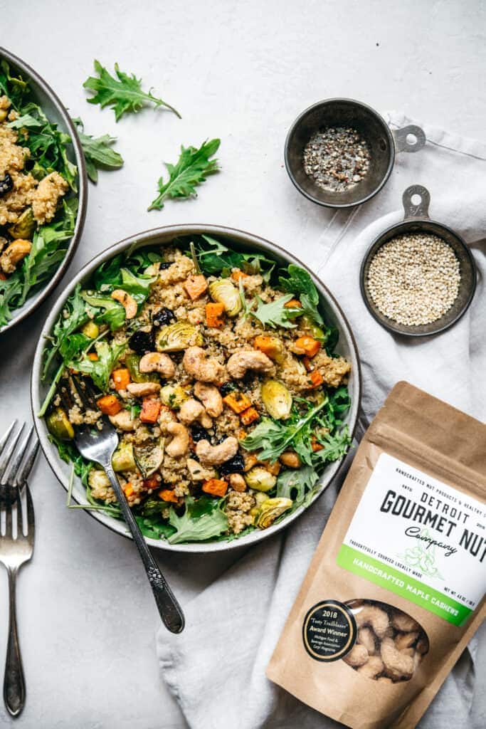overhead view of vegan quinoa salad with arugula and handcrafted maple cashews