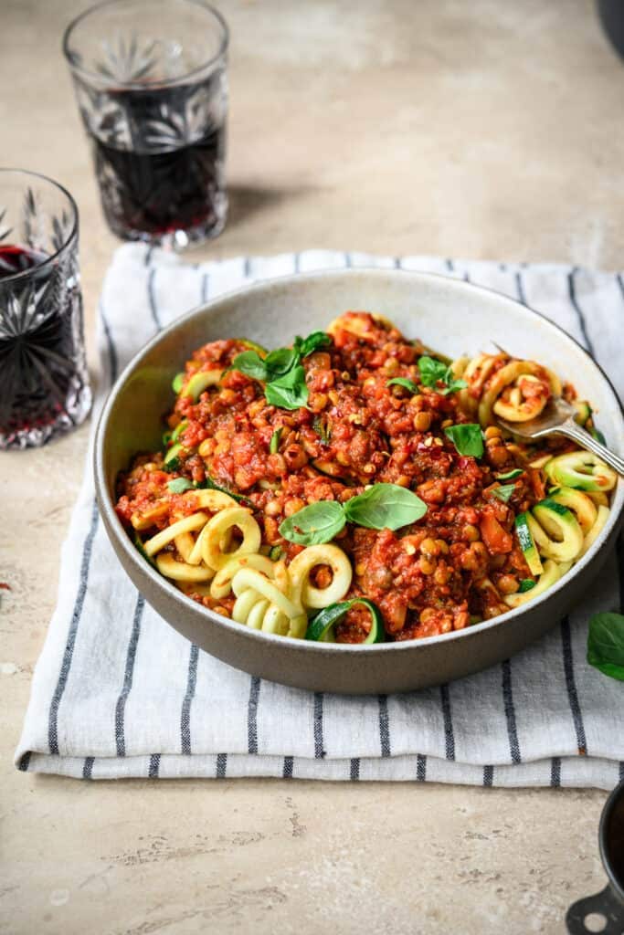 side view of vegan lentil bolognese sauce over zucchini noodles