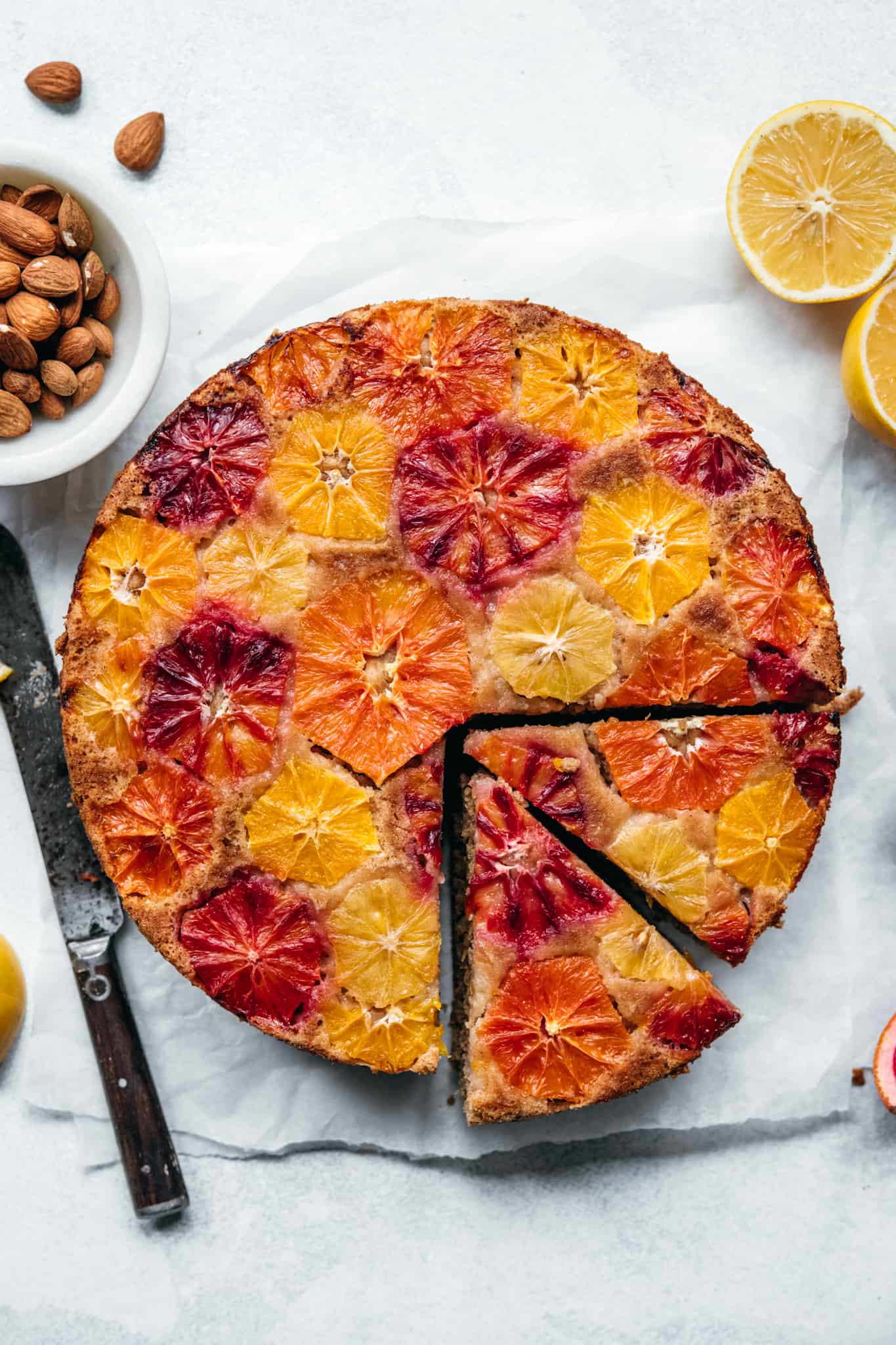 close up overhead of citrus upside down olive oil cake on white background