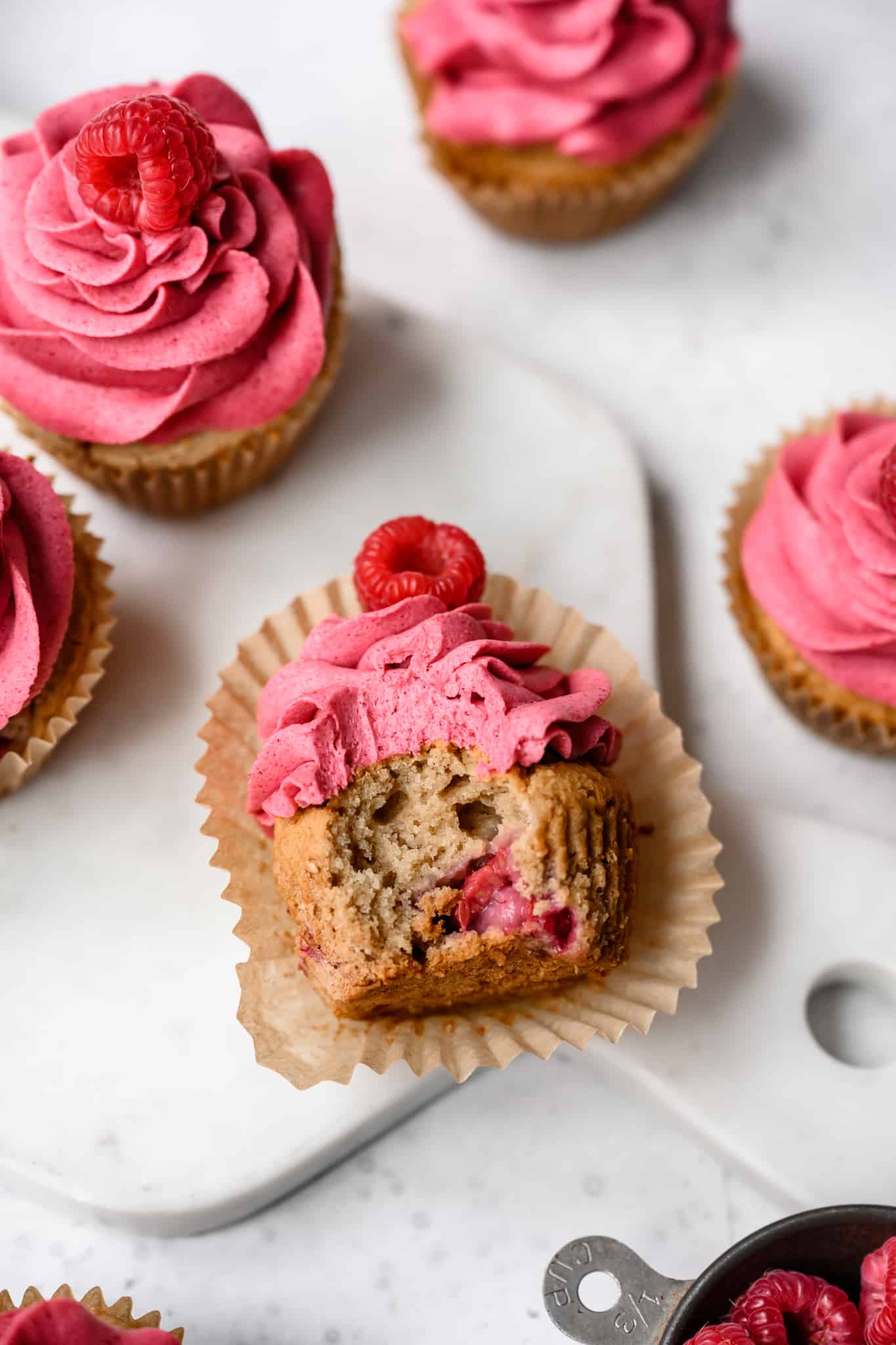 side view of raspberry almond cupcake with bite taken out