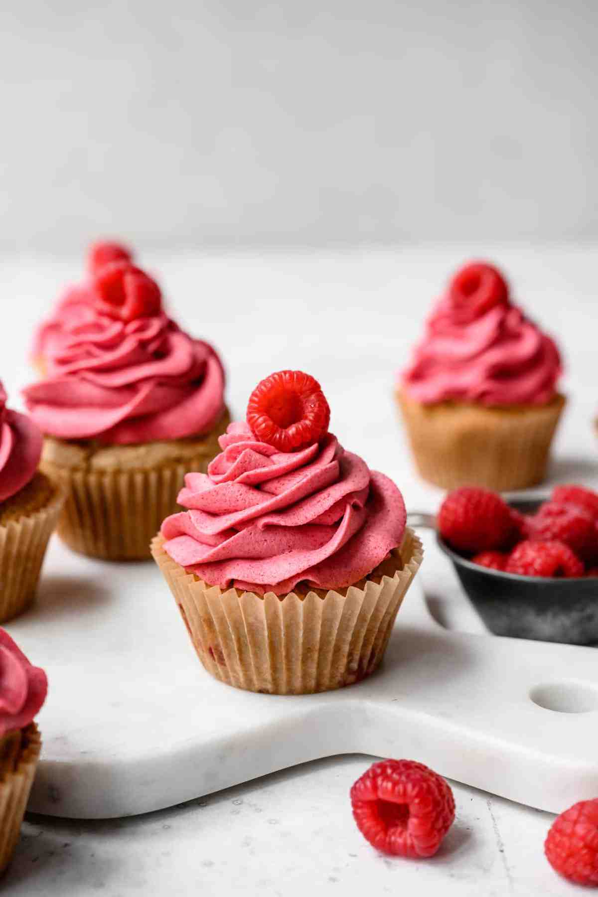 side view of vegan and gluten free raspberry cupcakes with pink buttercream