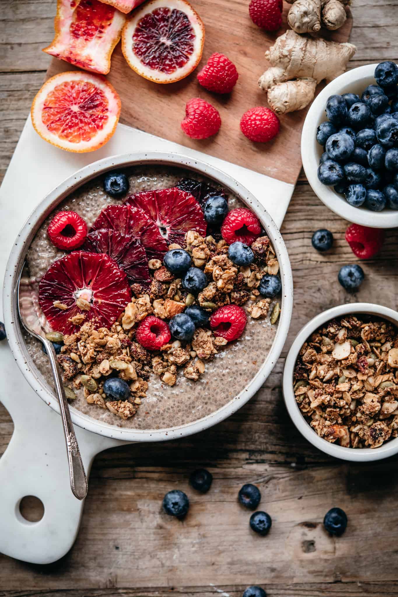 overhead view of chai chia pudding in white ceramic bowl with berries and granola