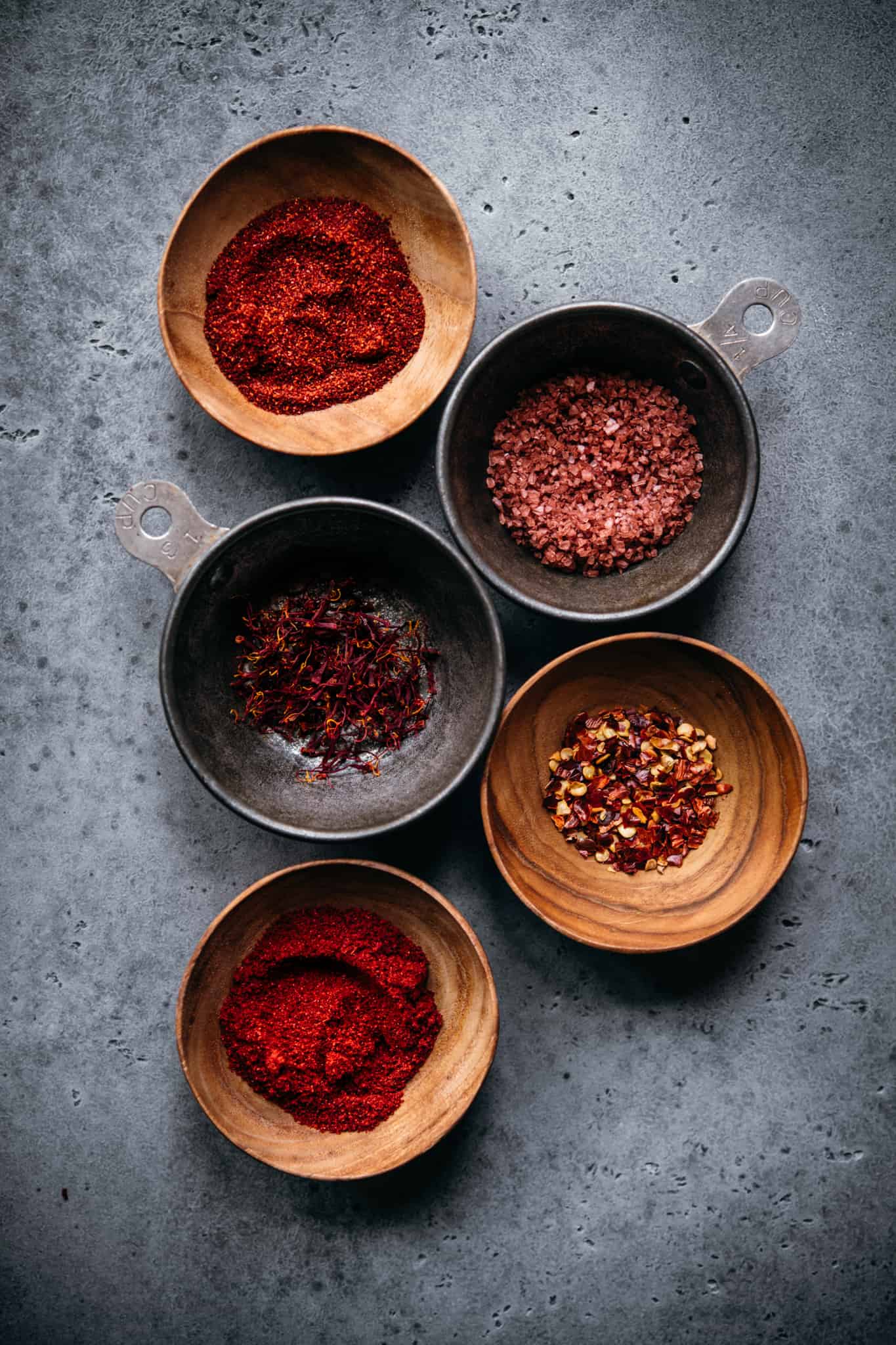 overhead view of spices in small bowls to use in vegan paella recipe