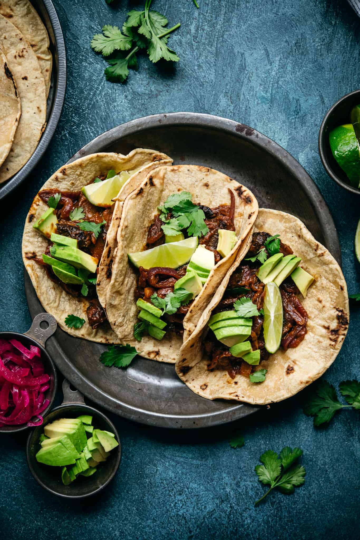 overhead view of vegan mushroom al pastor tacos with avocado and lime