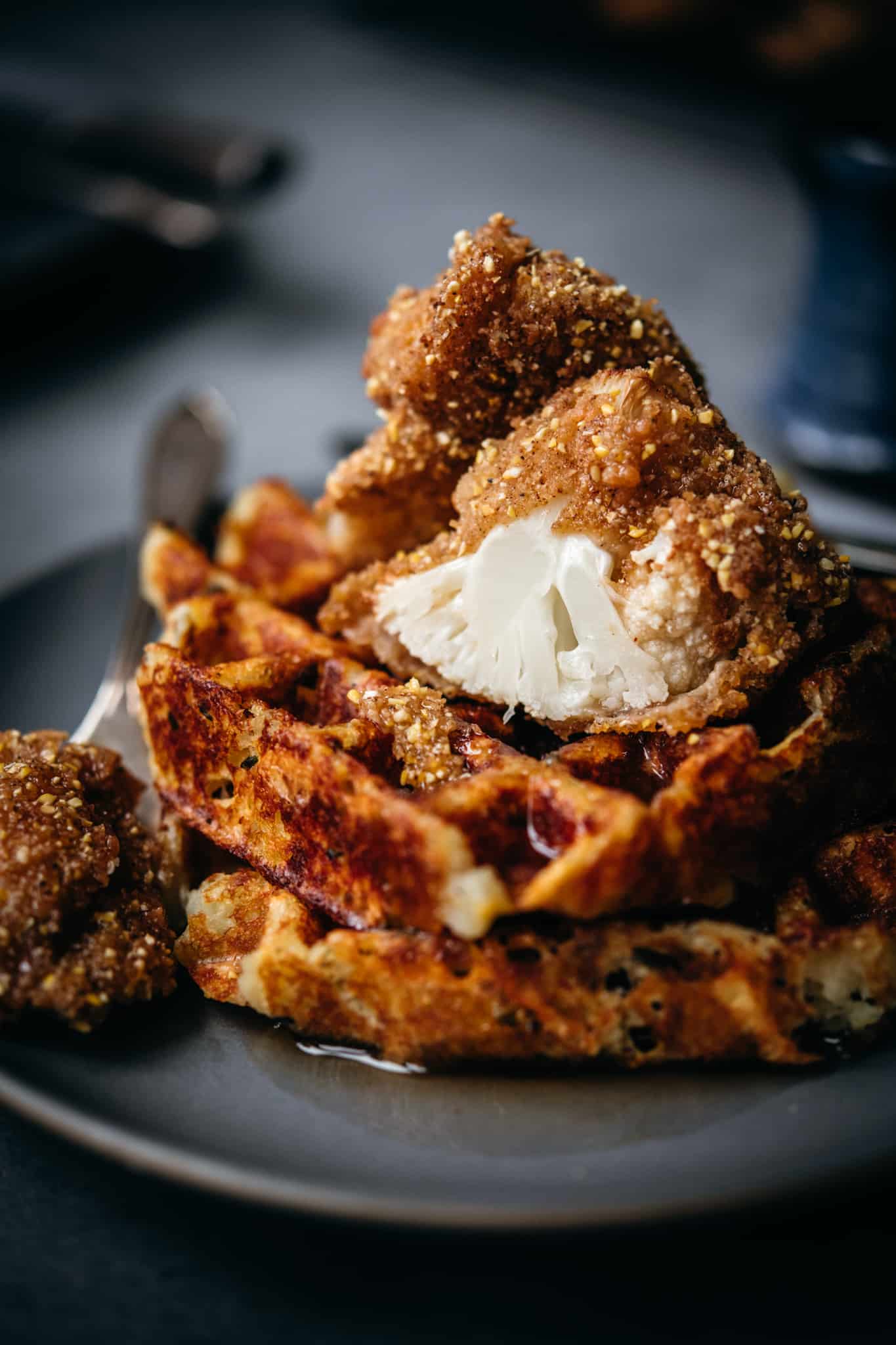 close up side view of vegan fried cauliflower on top of waffles