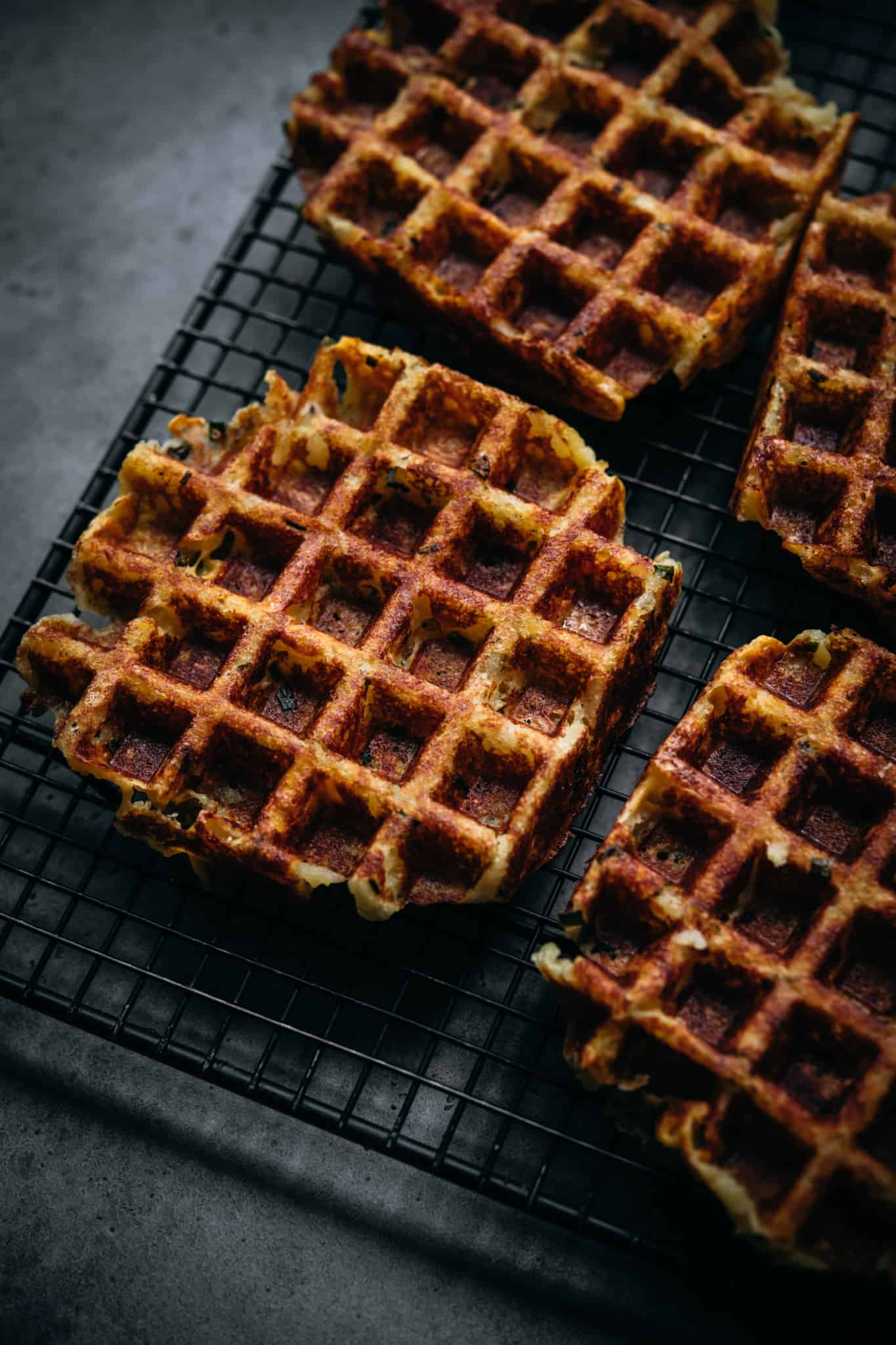 side view of crispy mashed potato waffles on cooling rack