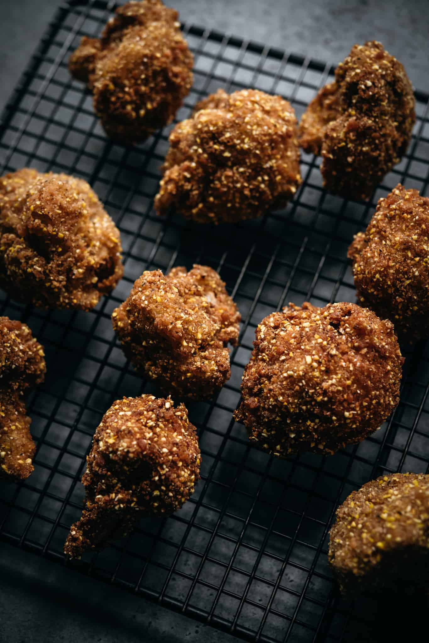 side view of vegan fried cauliflower bites on cooling rack