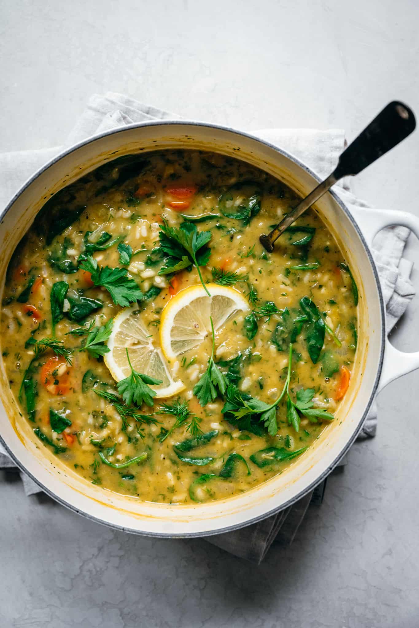 overhead view of lemon rice soup in white soup pot with ladle