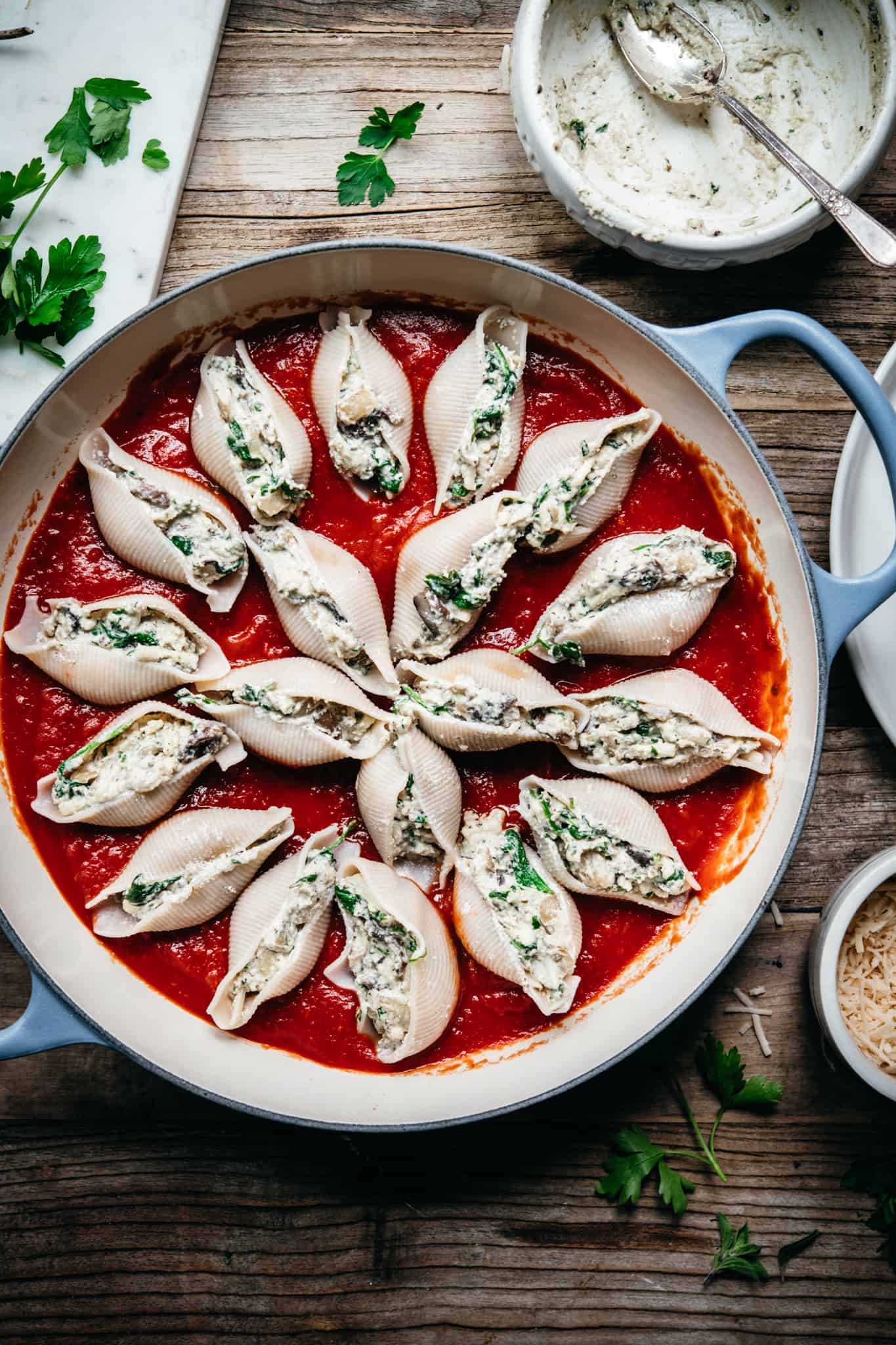 uncooked vegan stuffed shells with spinach mushroom ricotta filling on wood table